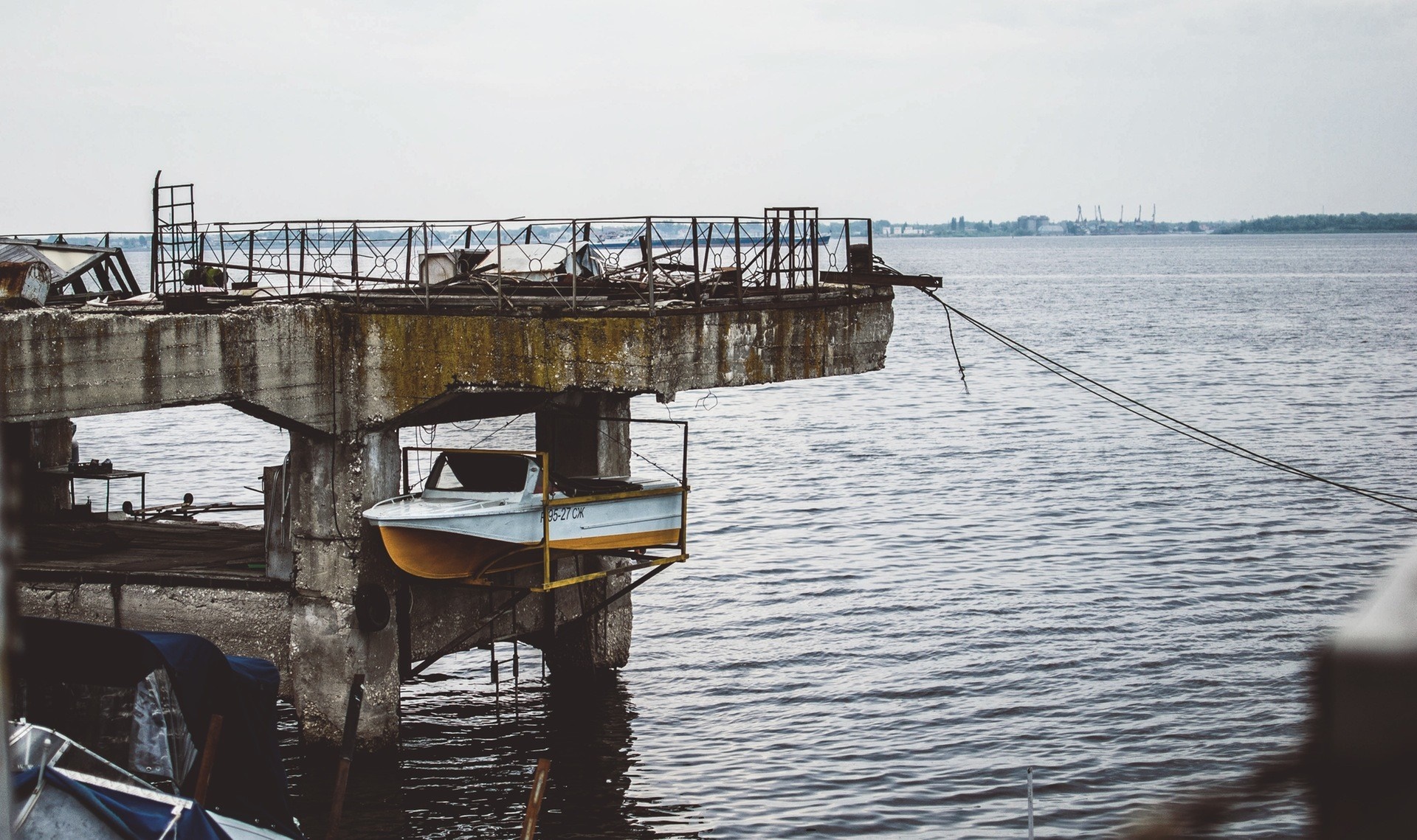 Boat suspended on a derelict pier over the water HD Wallpaper