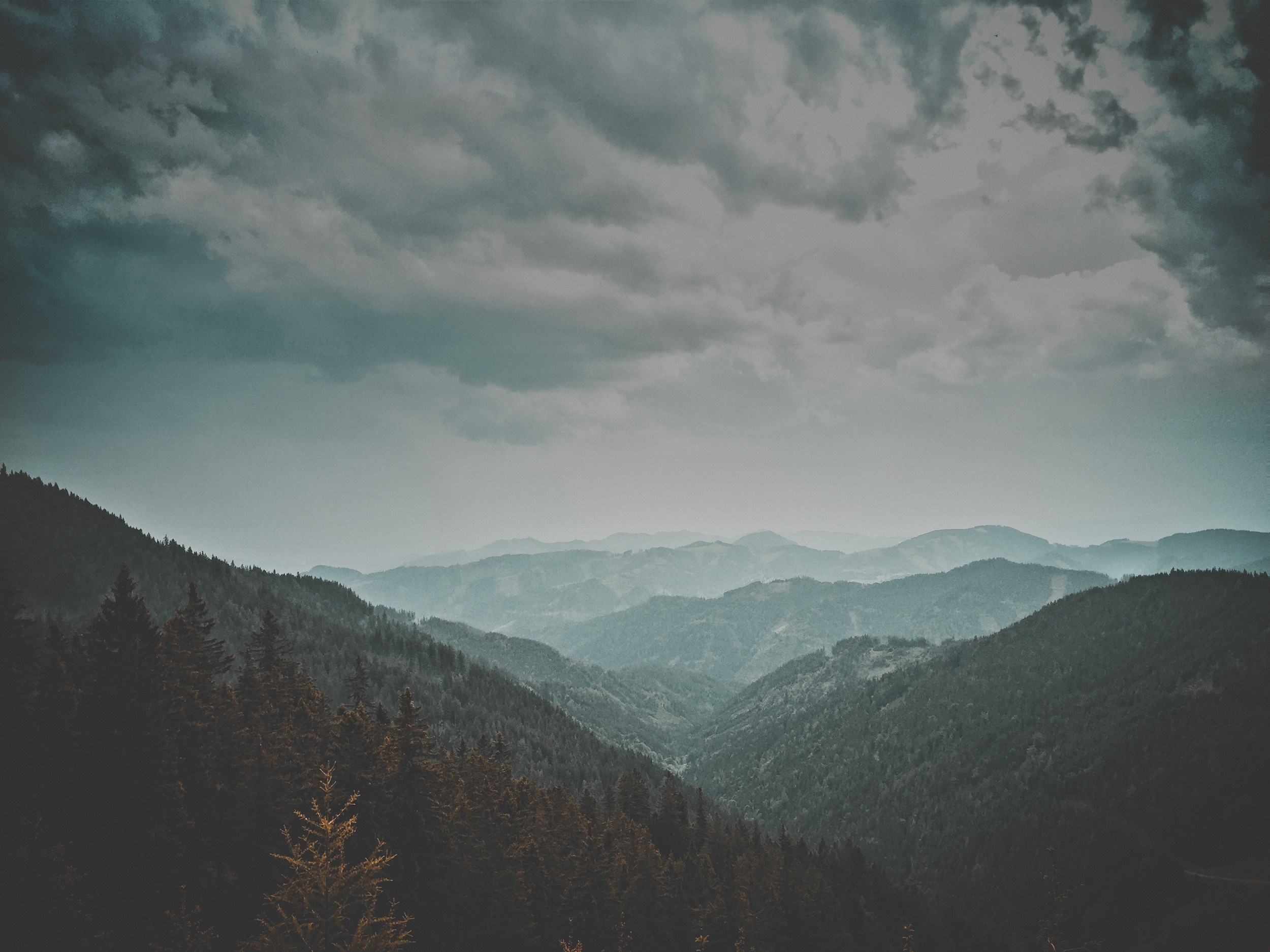 Misty mountain range with dark clouds HD Wallpaper