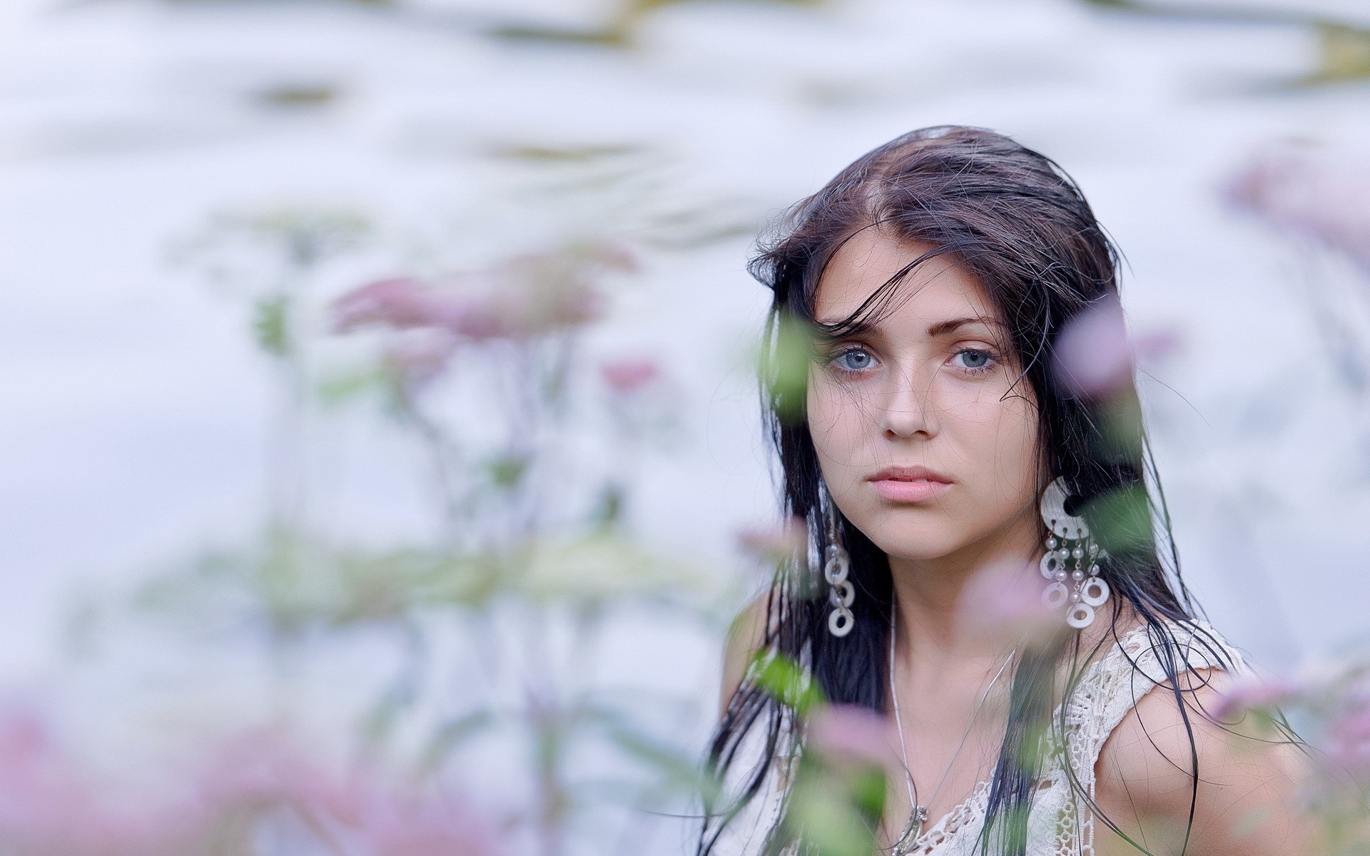 Woman with blue eyes and dark hair in nature HD Wallpaper