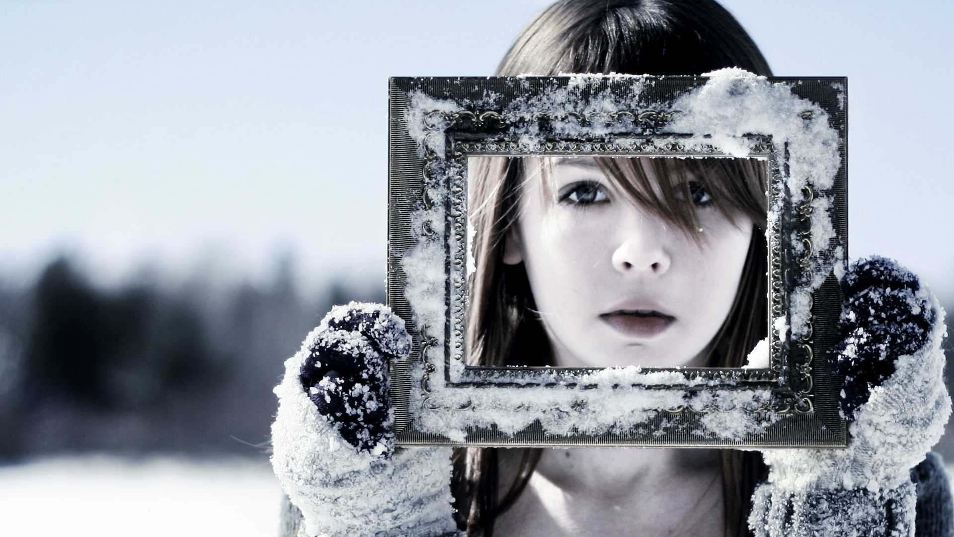Girl holding a snow-covered picture frame in winter HD Wallpaper