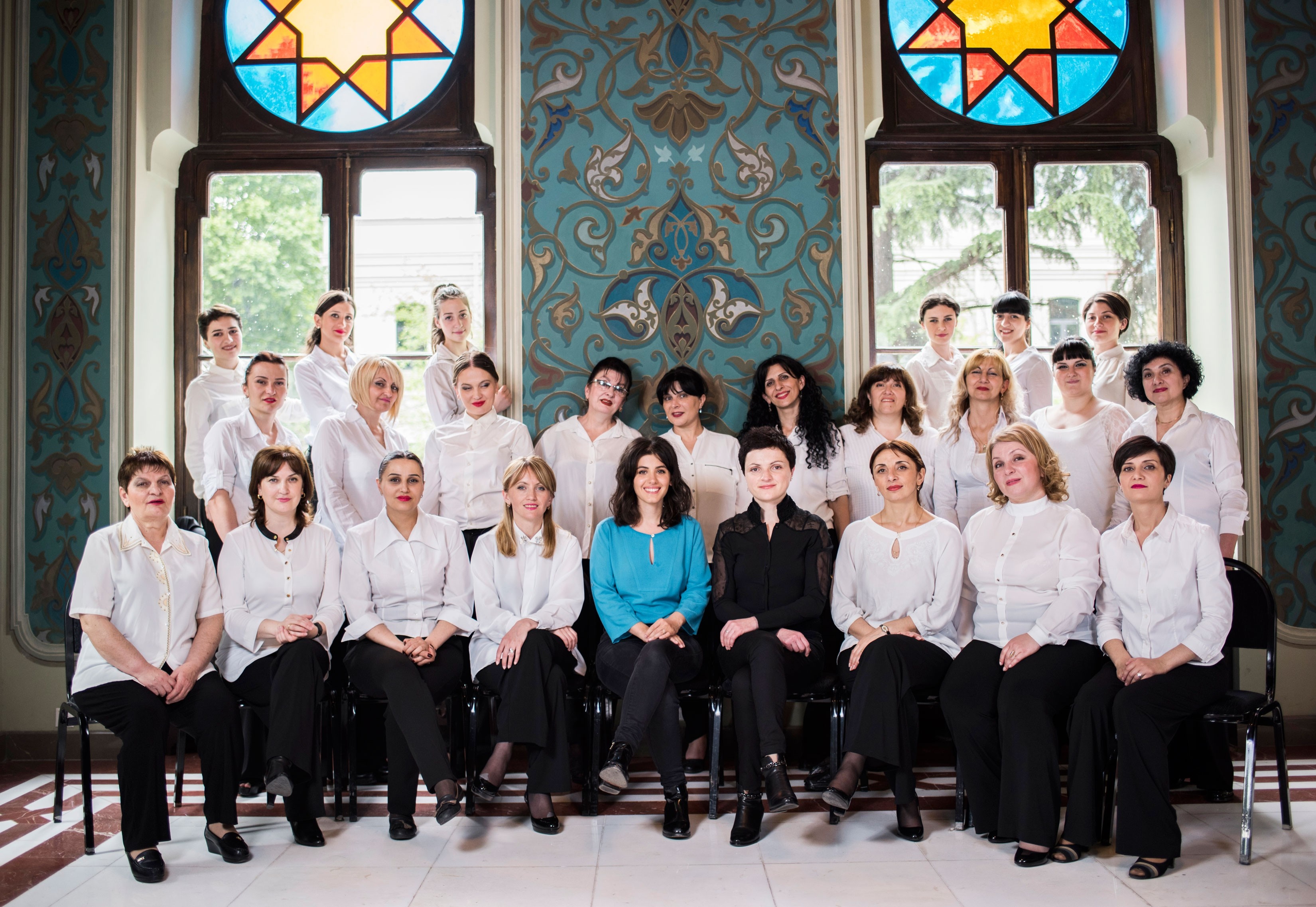 A choir of women in white shirts posing for a photo HD Wallpaper