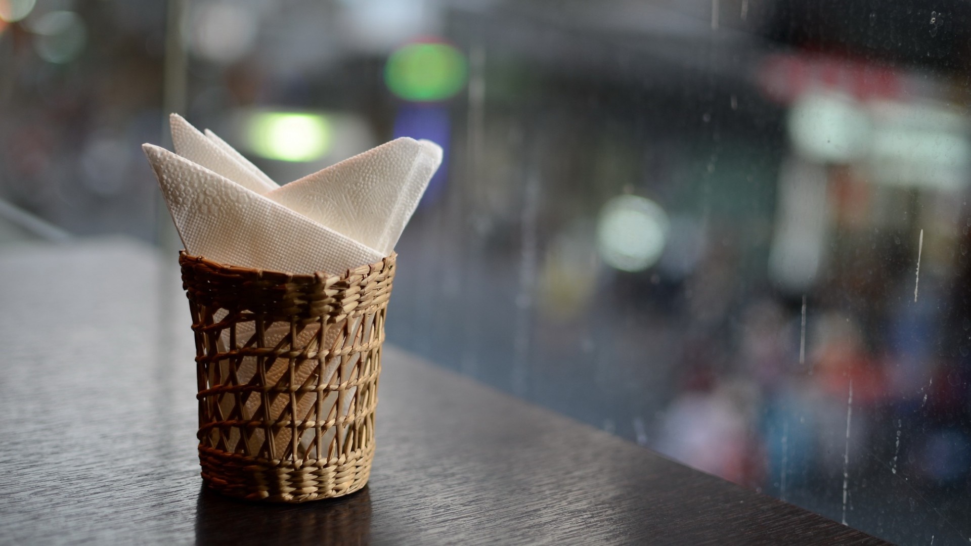 Napkins in a woven basket on a table HD Wallpaper