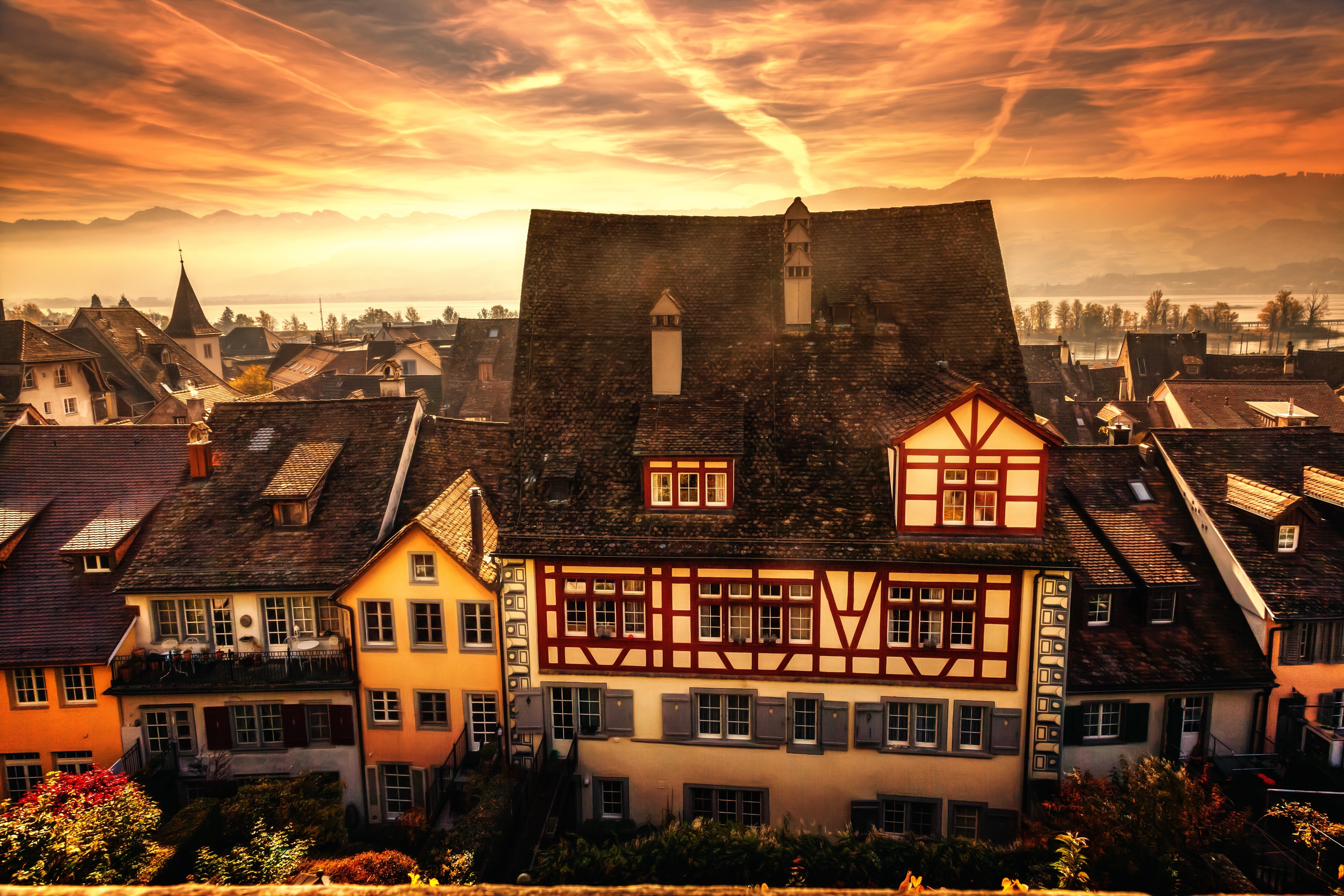 Townscape at sunset with mountains and lake HD Wallpaper