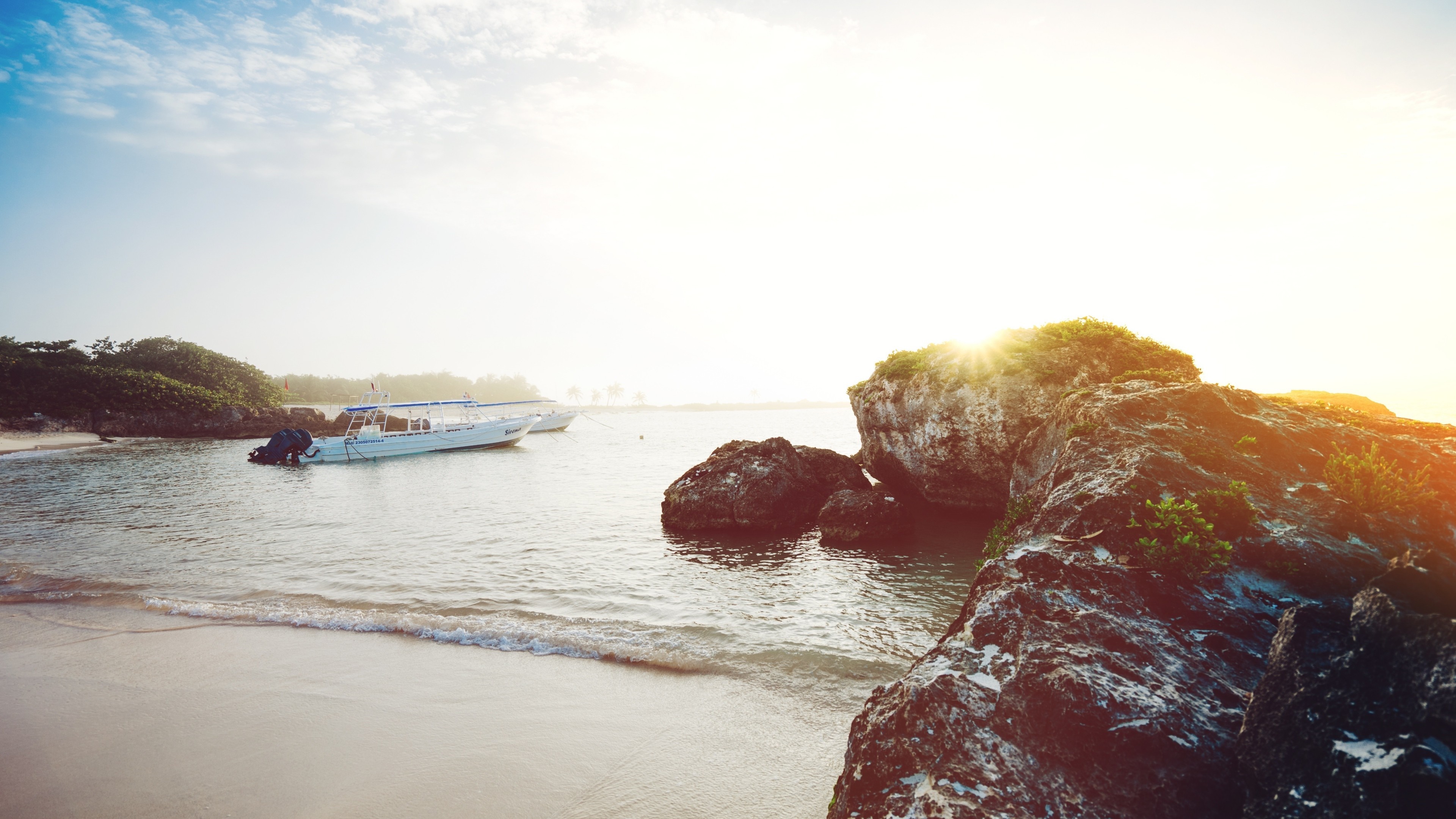 Boats anchored near rocky shore at sunrise HD Wallpaper