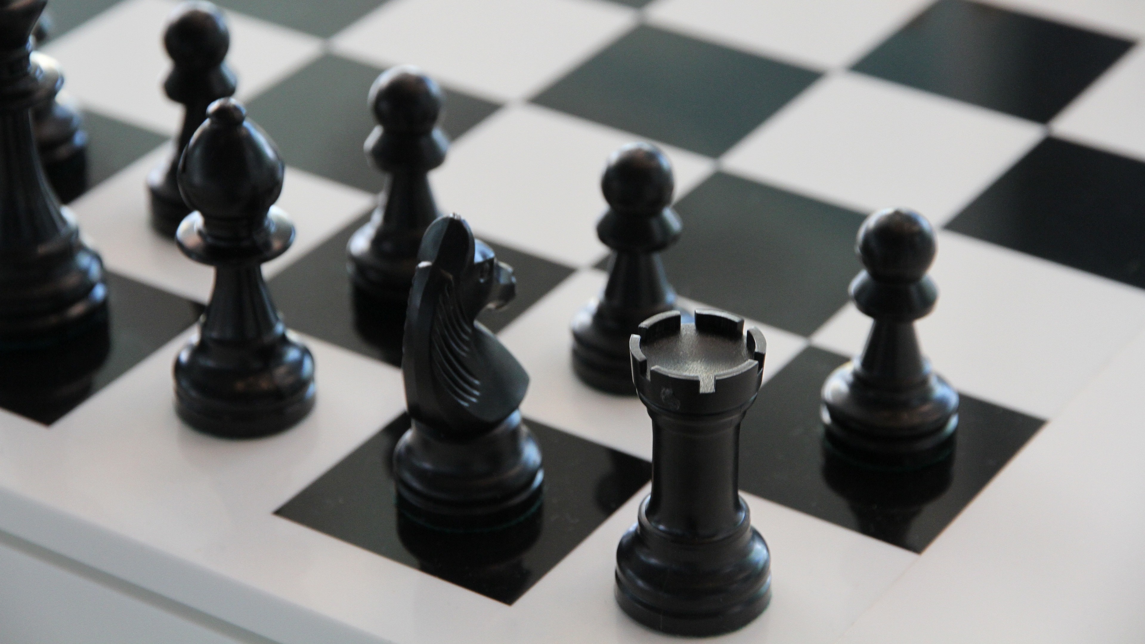 Black chess pieces on a chessboard HD Wallpaper