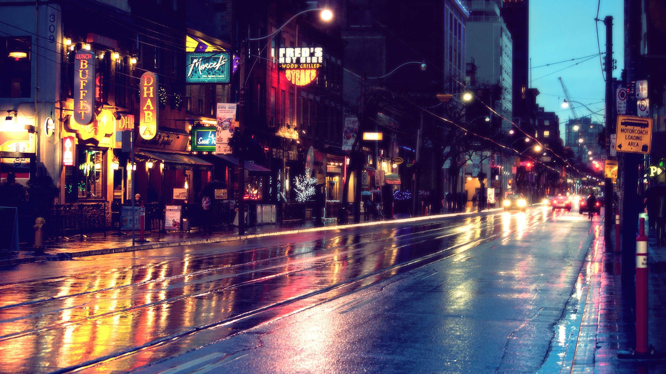 City street at night with wet reflections and traffic HD Wallpaper