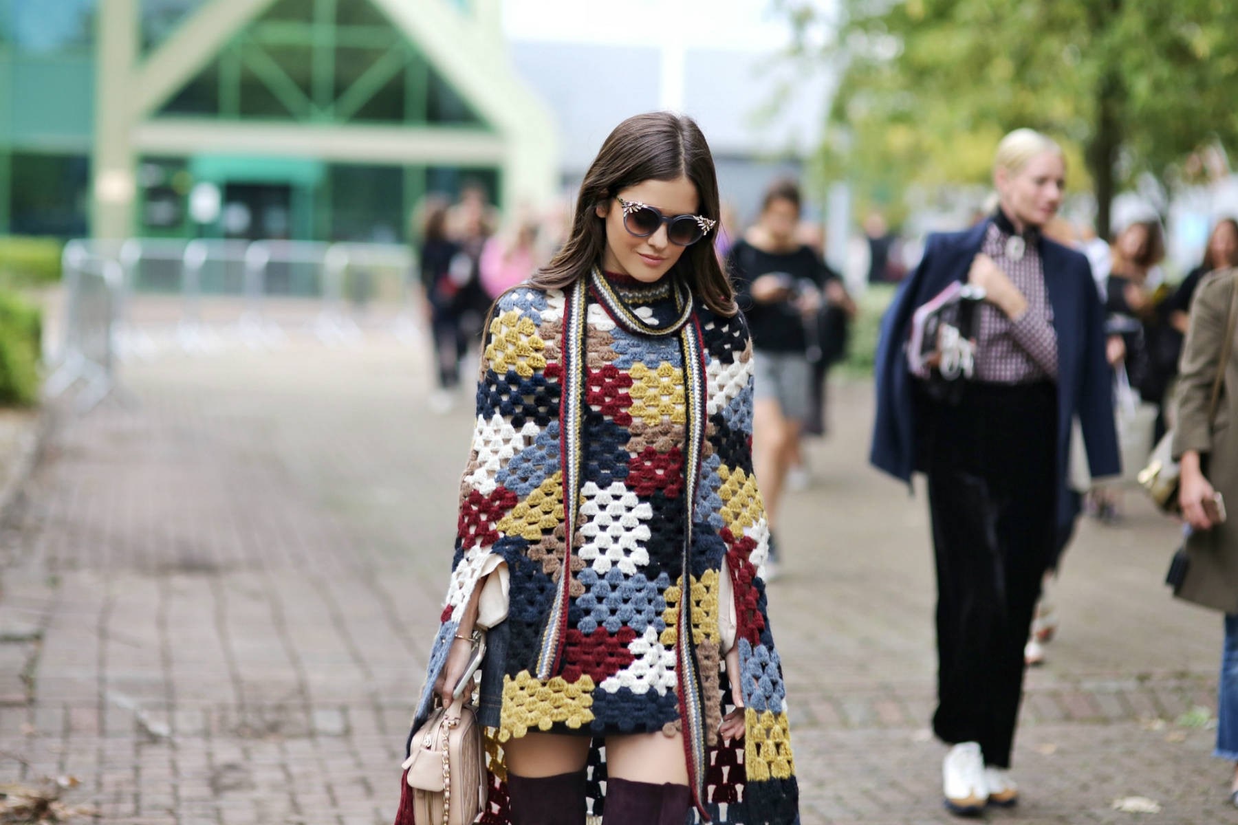Woman wearing a colorful crochet poncho and sunglasses HD Wallpaper
