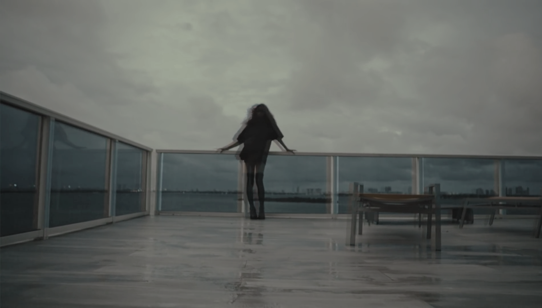Woman on a balcony overlooking a city skyline HD Wallpaper