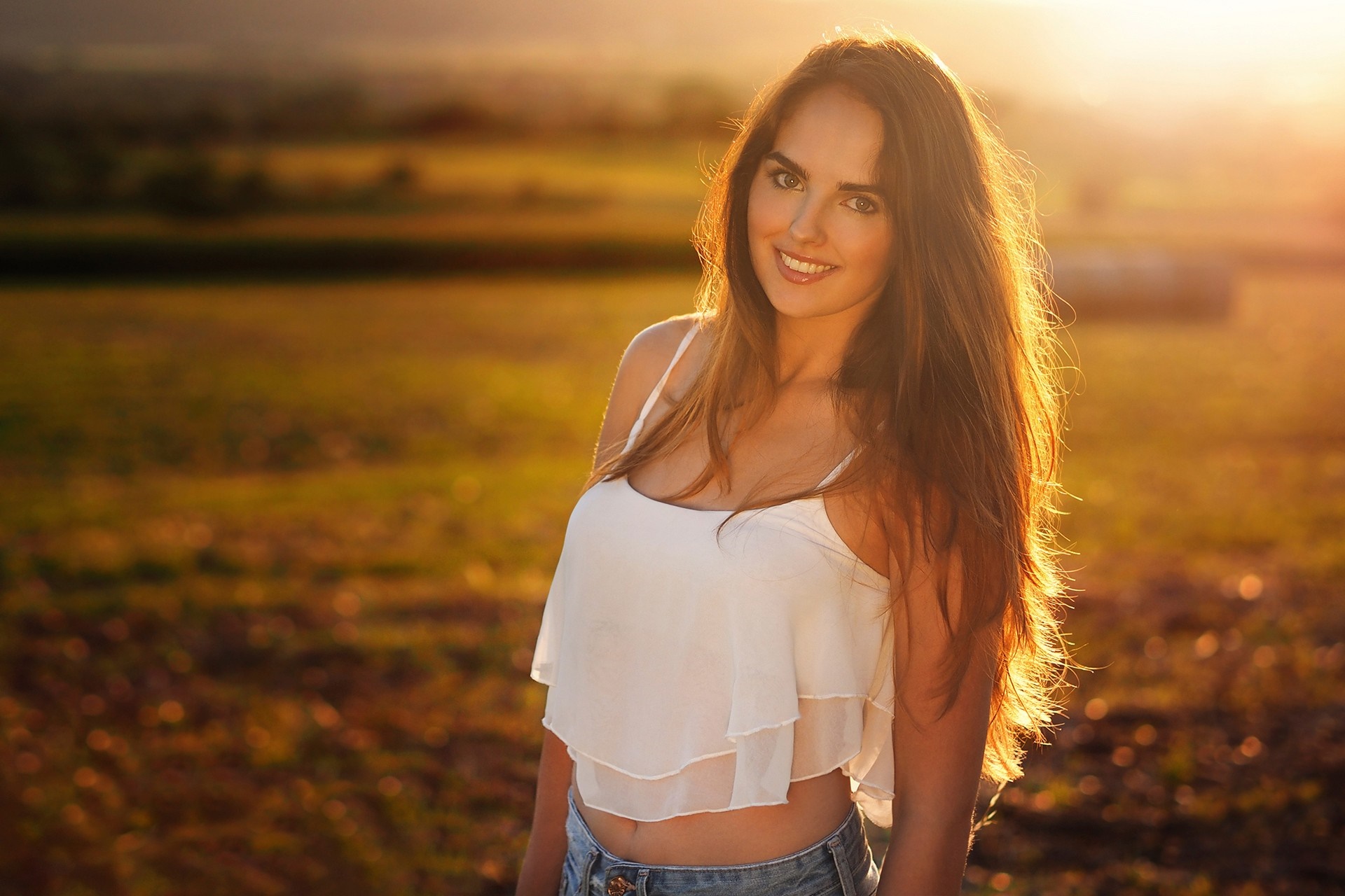 Woman in white crop top and jeans smiling in field HD Wallpaper
