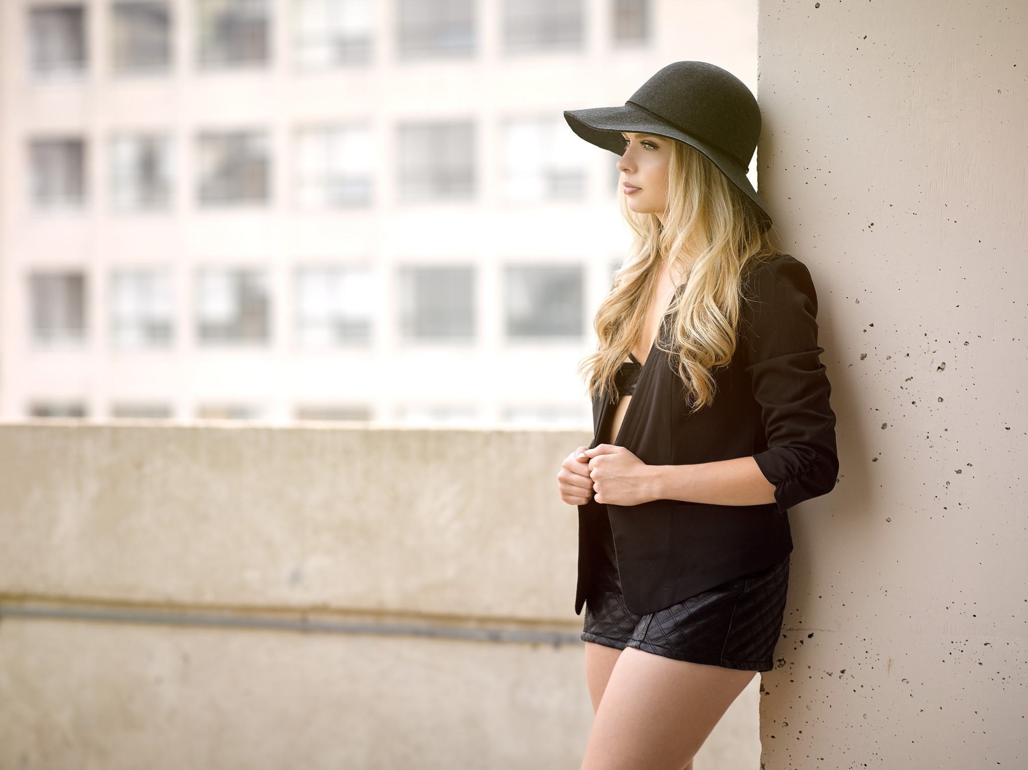 Woman in black hat and jacket posing outdoors HD Wallpaper