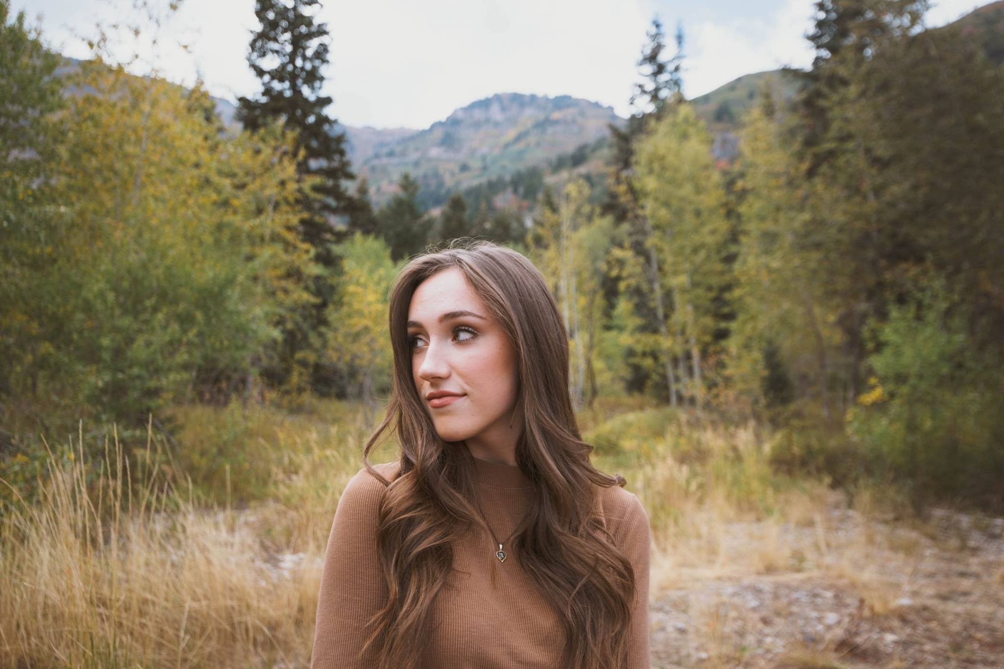 Young woman in a brown turtleneck in a forest during fall HD Wallpaper