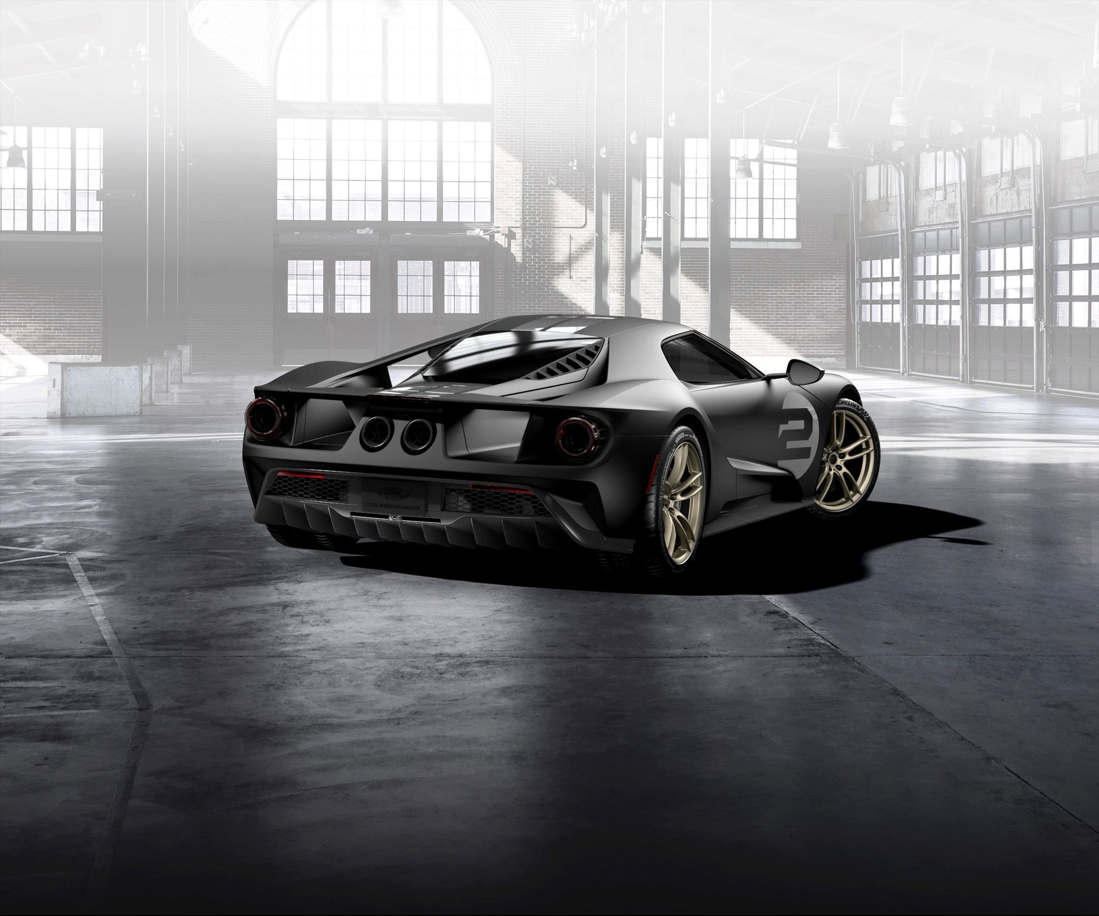 Matte black Ford GT with gold wheels in a warehouse HD Wallpaper