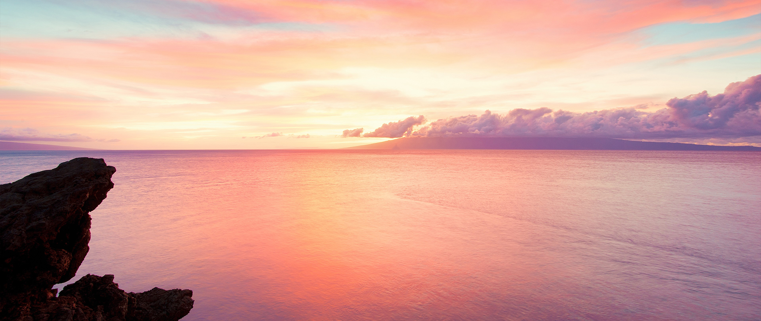 Ocean sunset with rocky cliff and distant island HD Wallpaper