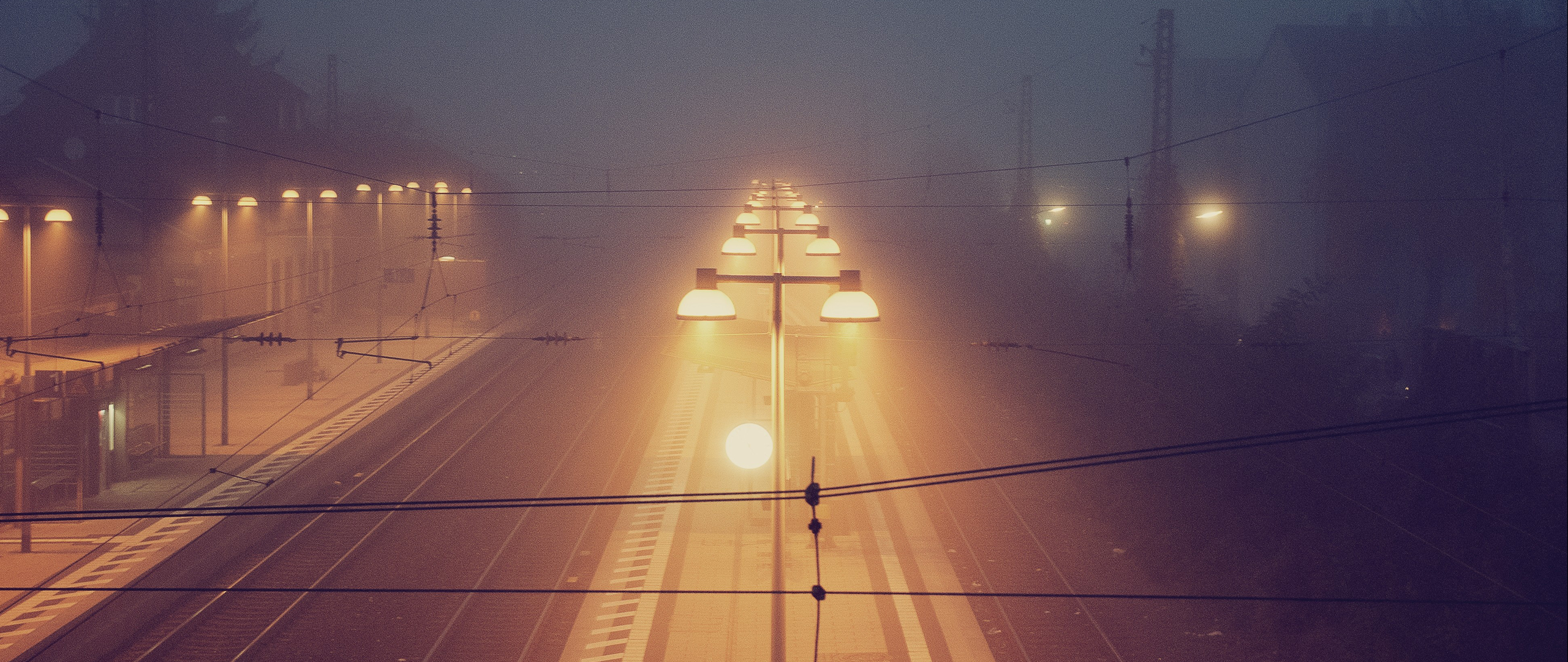 Train station lights in the fog at dawn HD Wallpaper