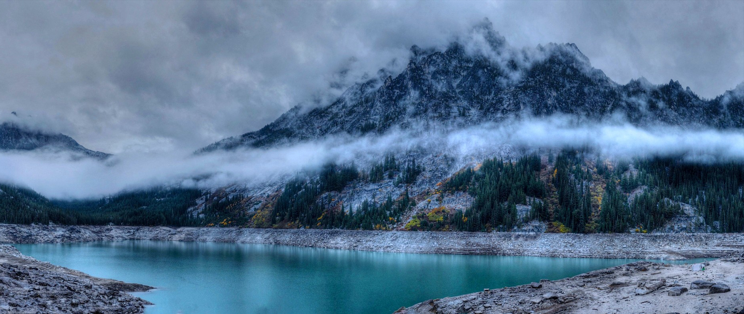Misty mountains over a turquoise lake HD Wallpaper