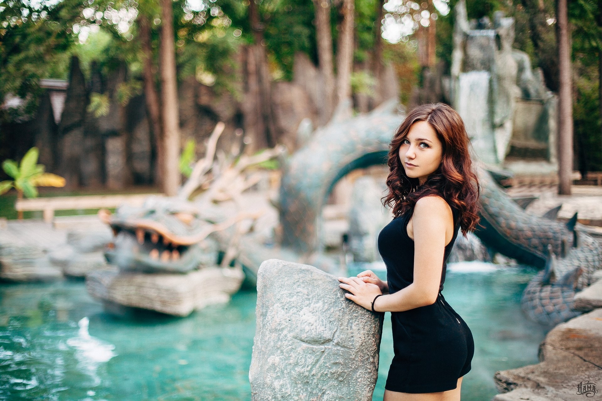 Woman in black dress posing by a dragon fountain HD Wallpaper