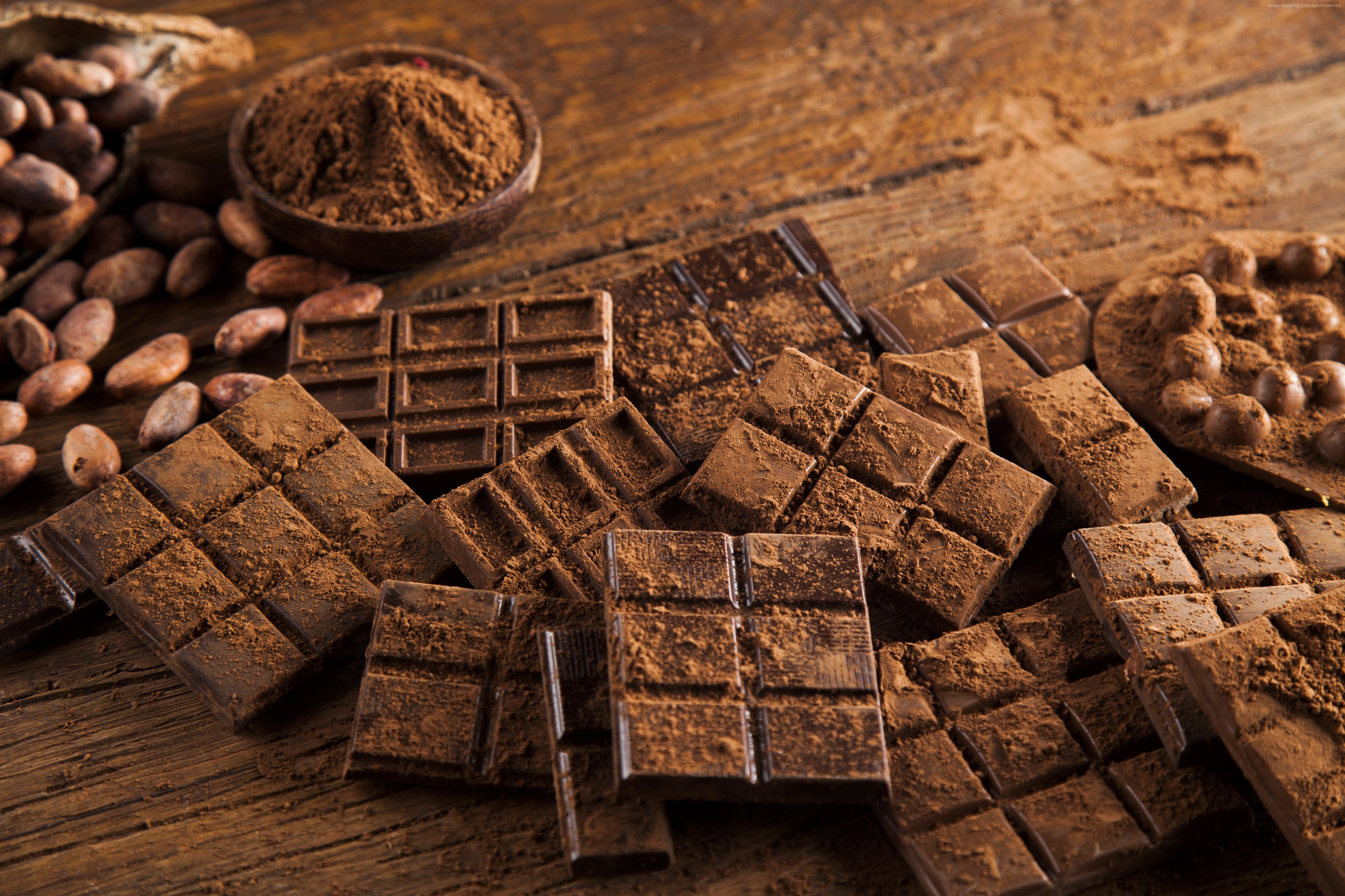 Chocolate bars and cocoa beans on wooden table HD Wallpaper
