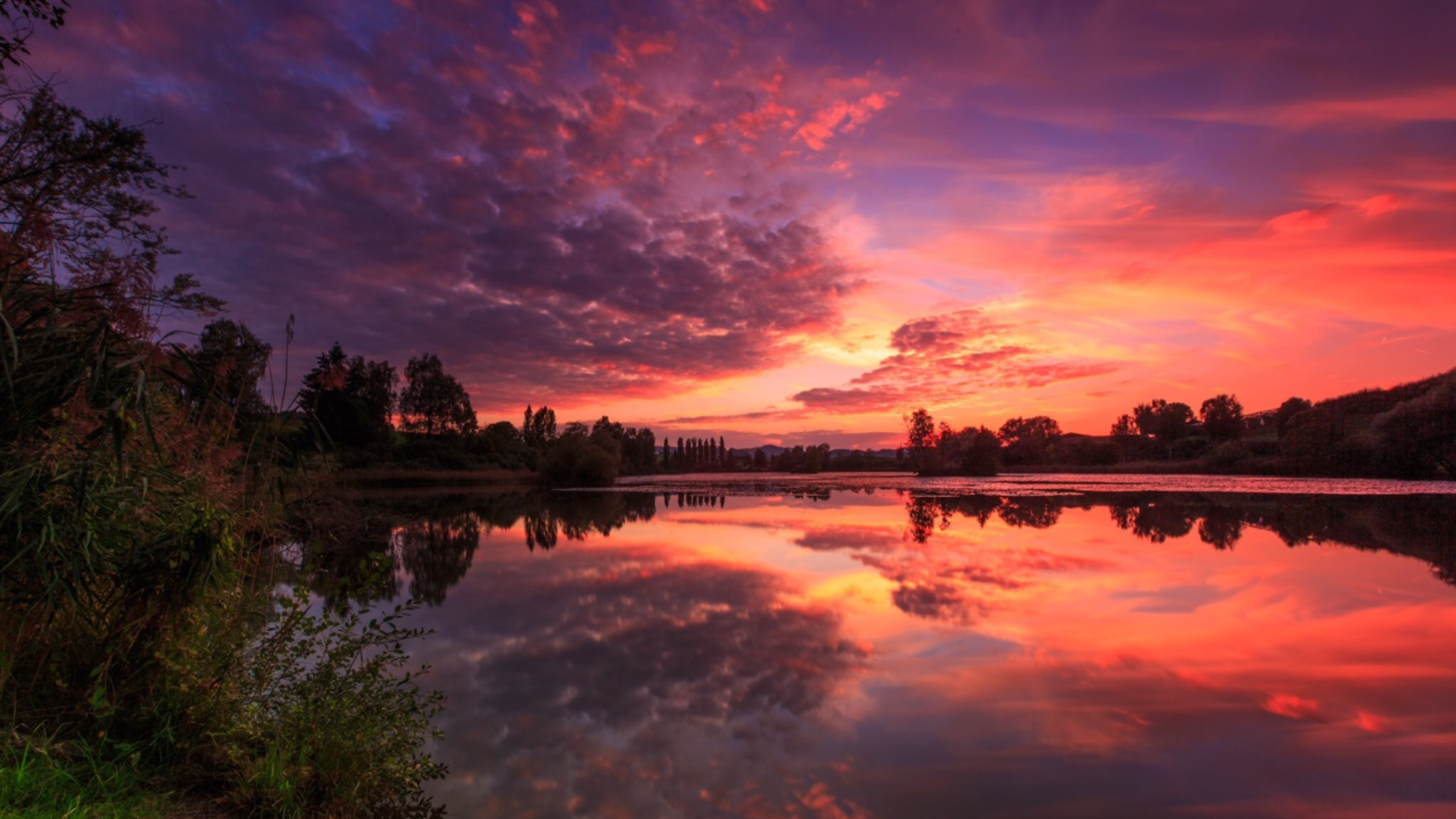 Sunset over a lake with colorful clouds and reflections HD Wallpaper