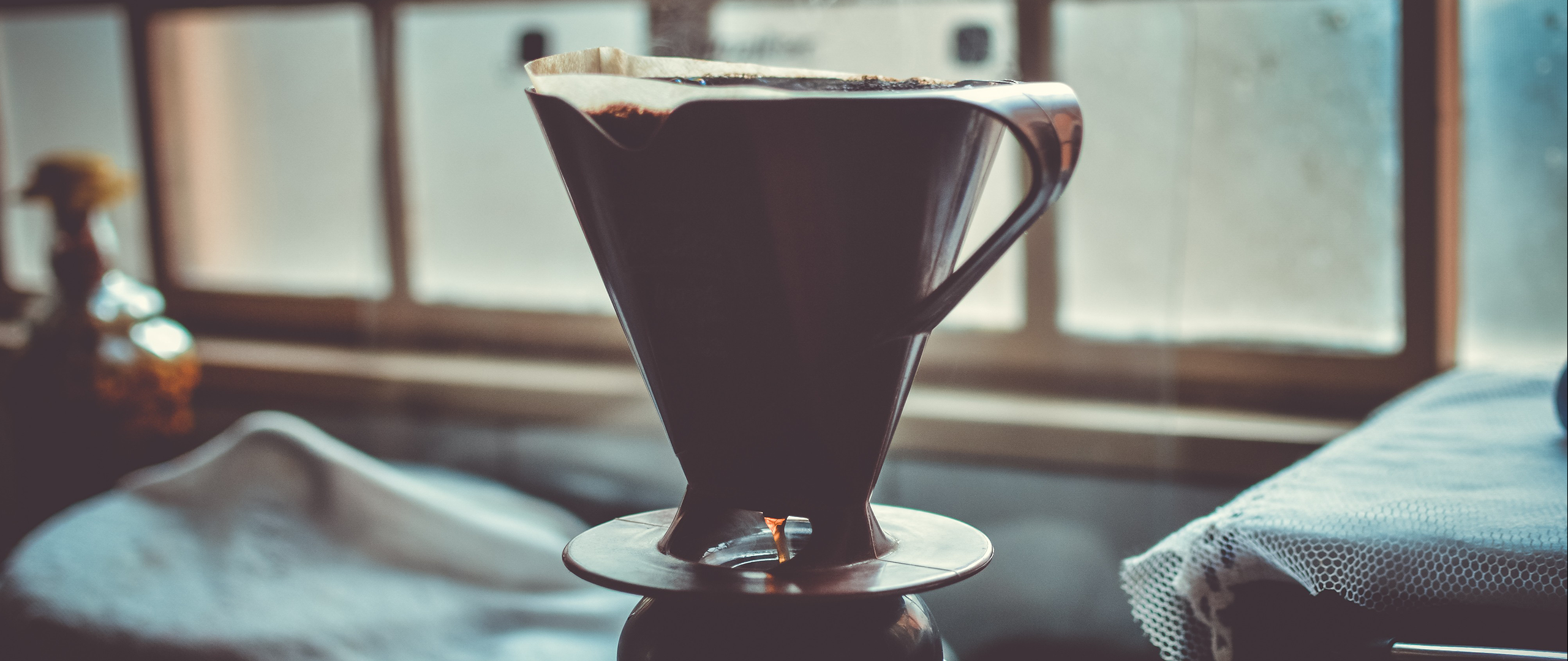 Pour-over coffee brewing in a dark brown filter cone HD Wallpaper