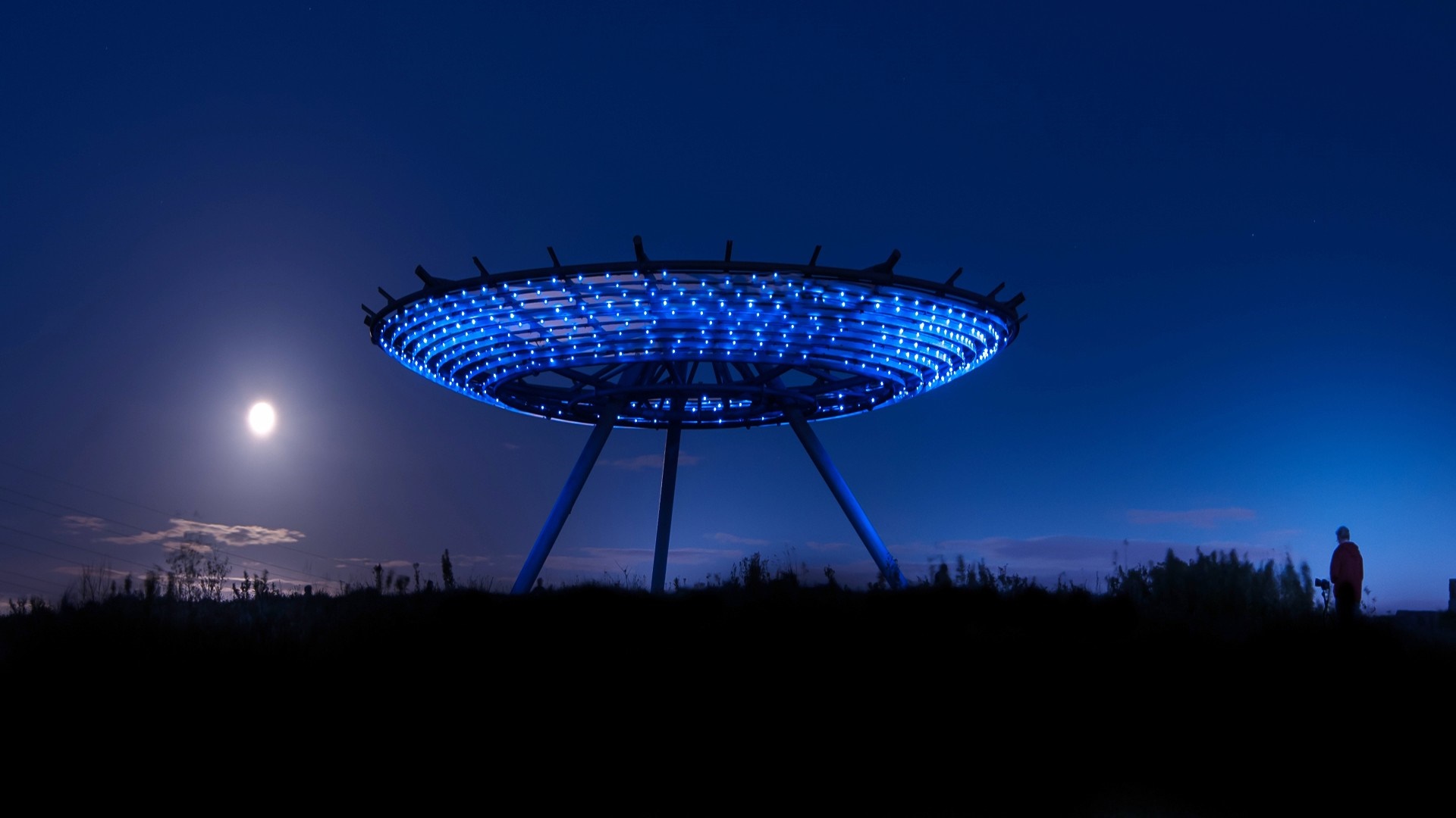 UFO-shaped structure with blue lights at night HD Wallpaper