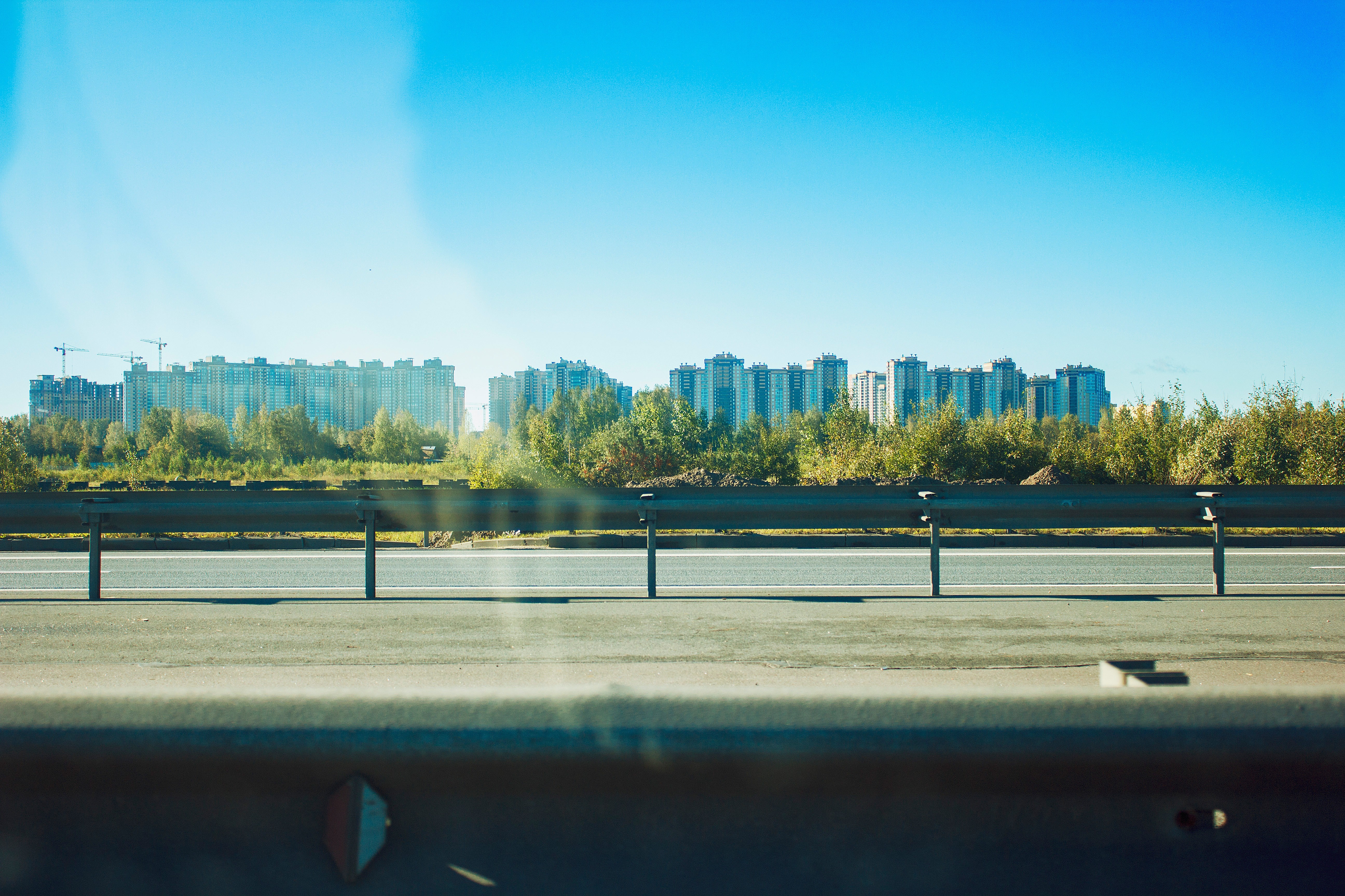 Apartment buildings and trees along a highway HD Wallpaper
