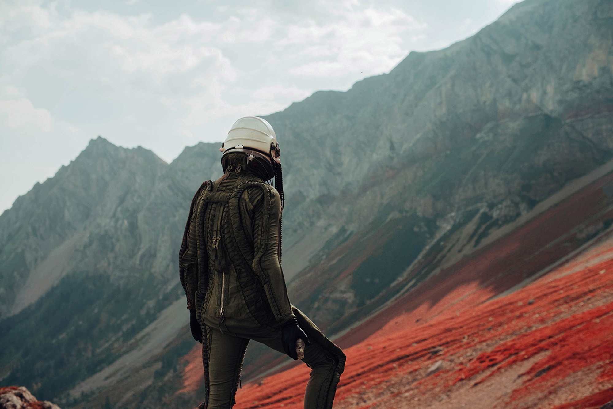 Person in pressure suit on red mountain slope HD Wallpaper