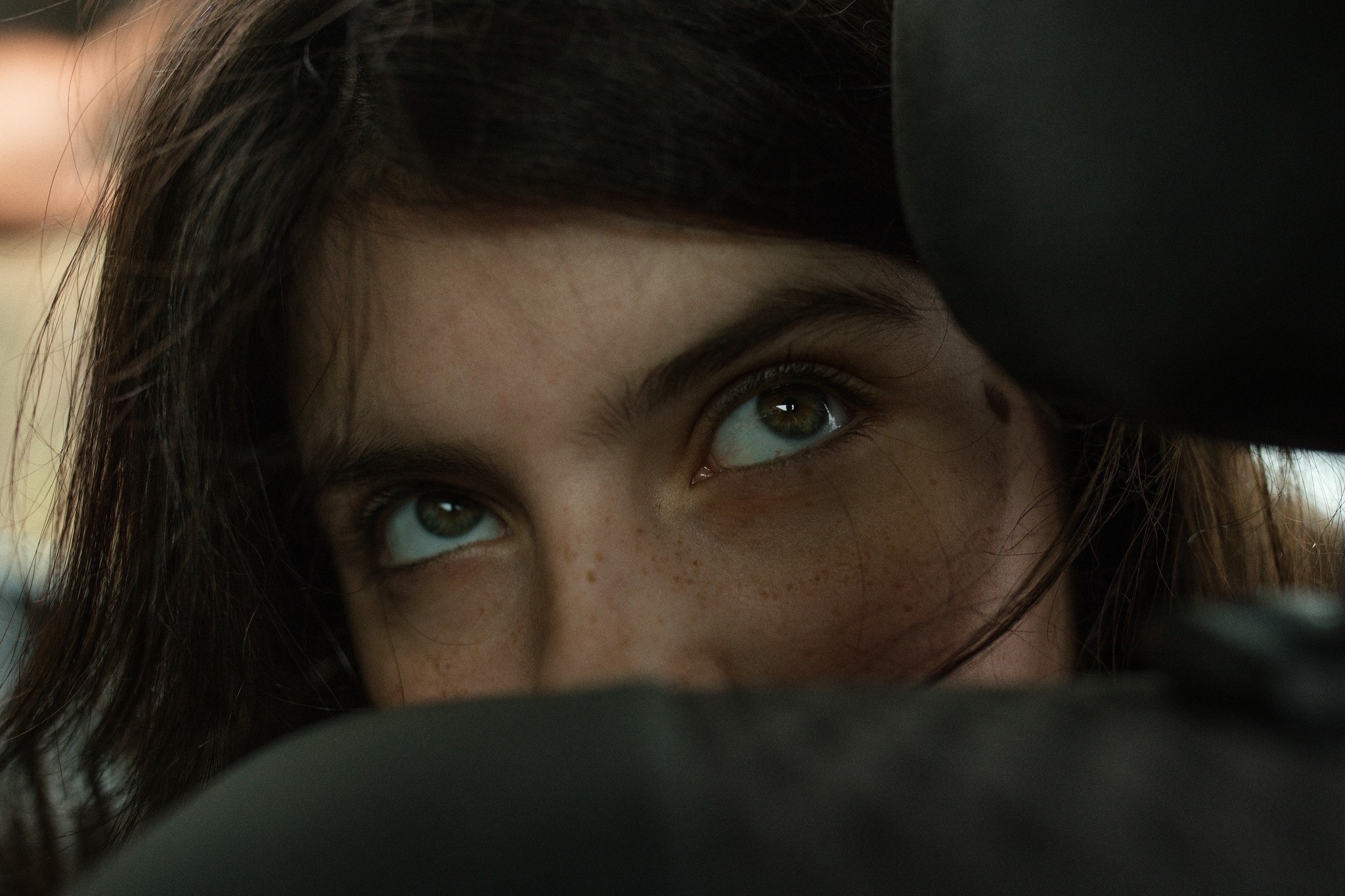 Close-up of a young woman with freckles looking up HD Wallpaper
