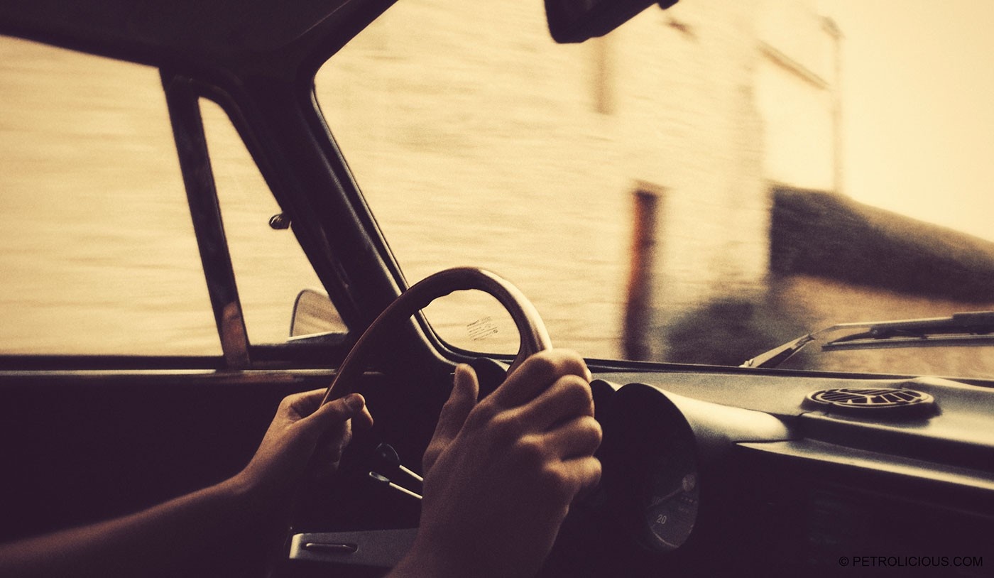 Hands on the steering wheel of a vintage car HD Wallpaper