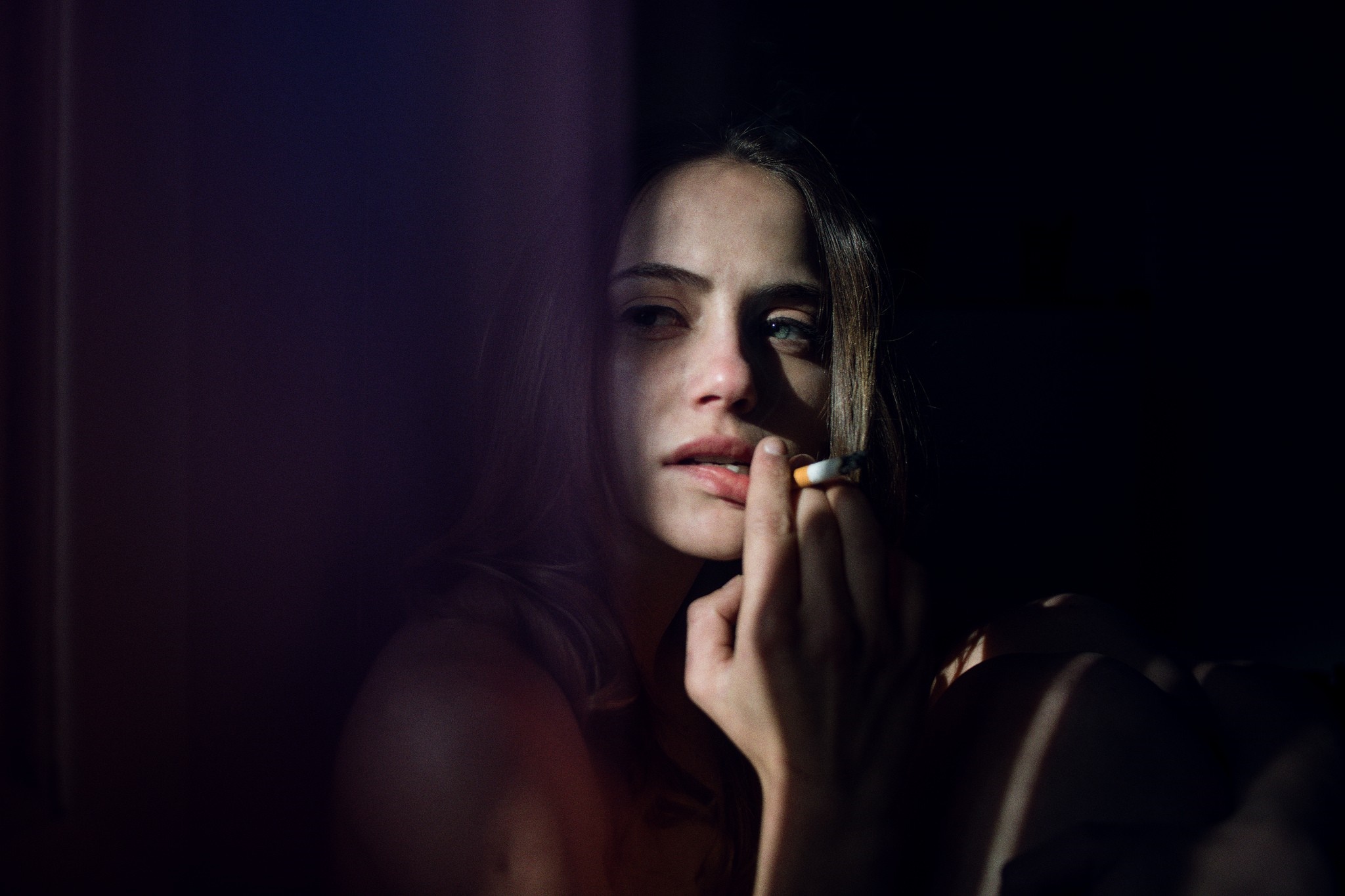 Woman smoking a cigarette in the dark HD Wallpaper