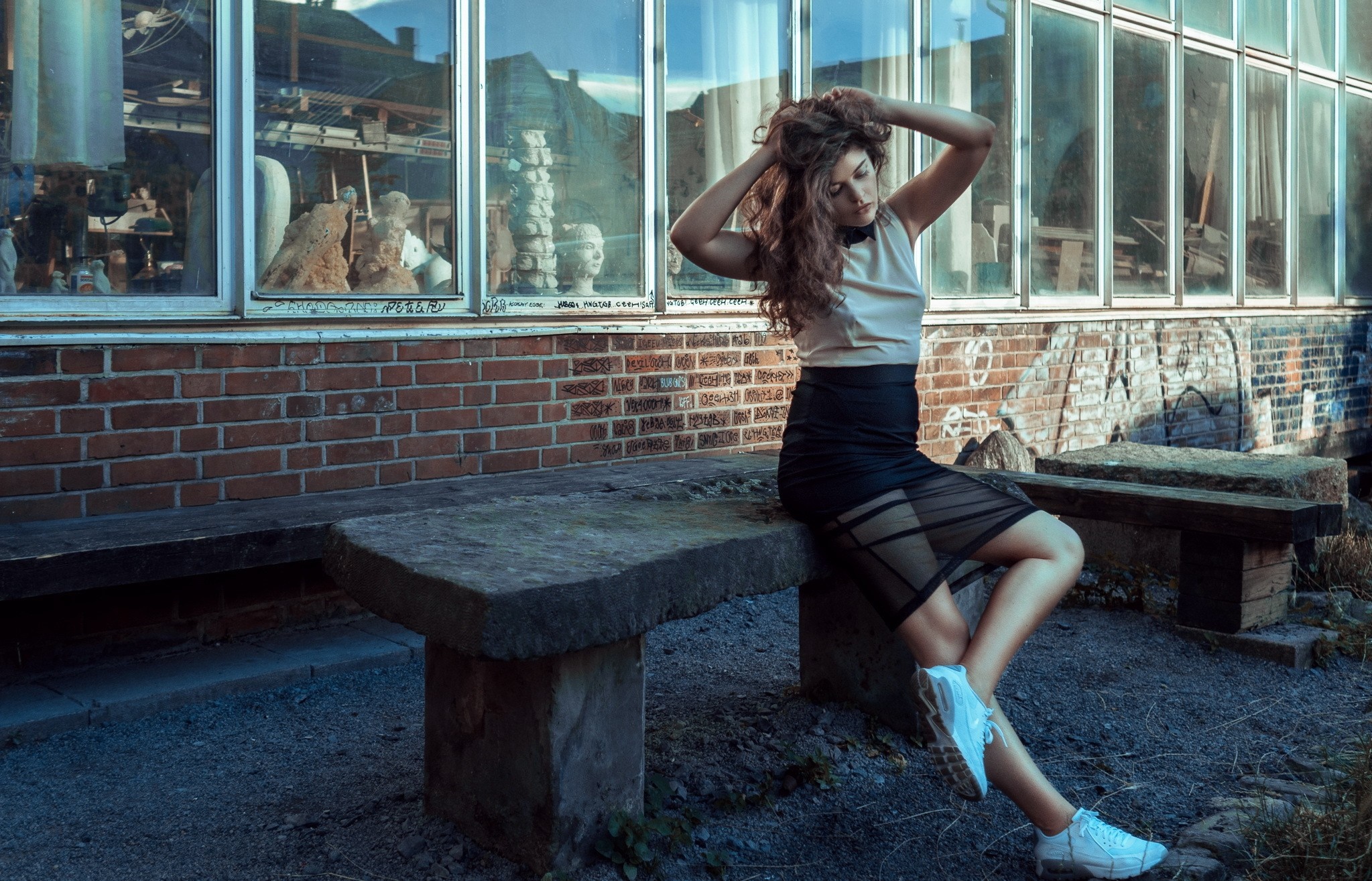Woman with long hair sitting on a stone bench HD Wallpaper