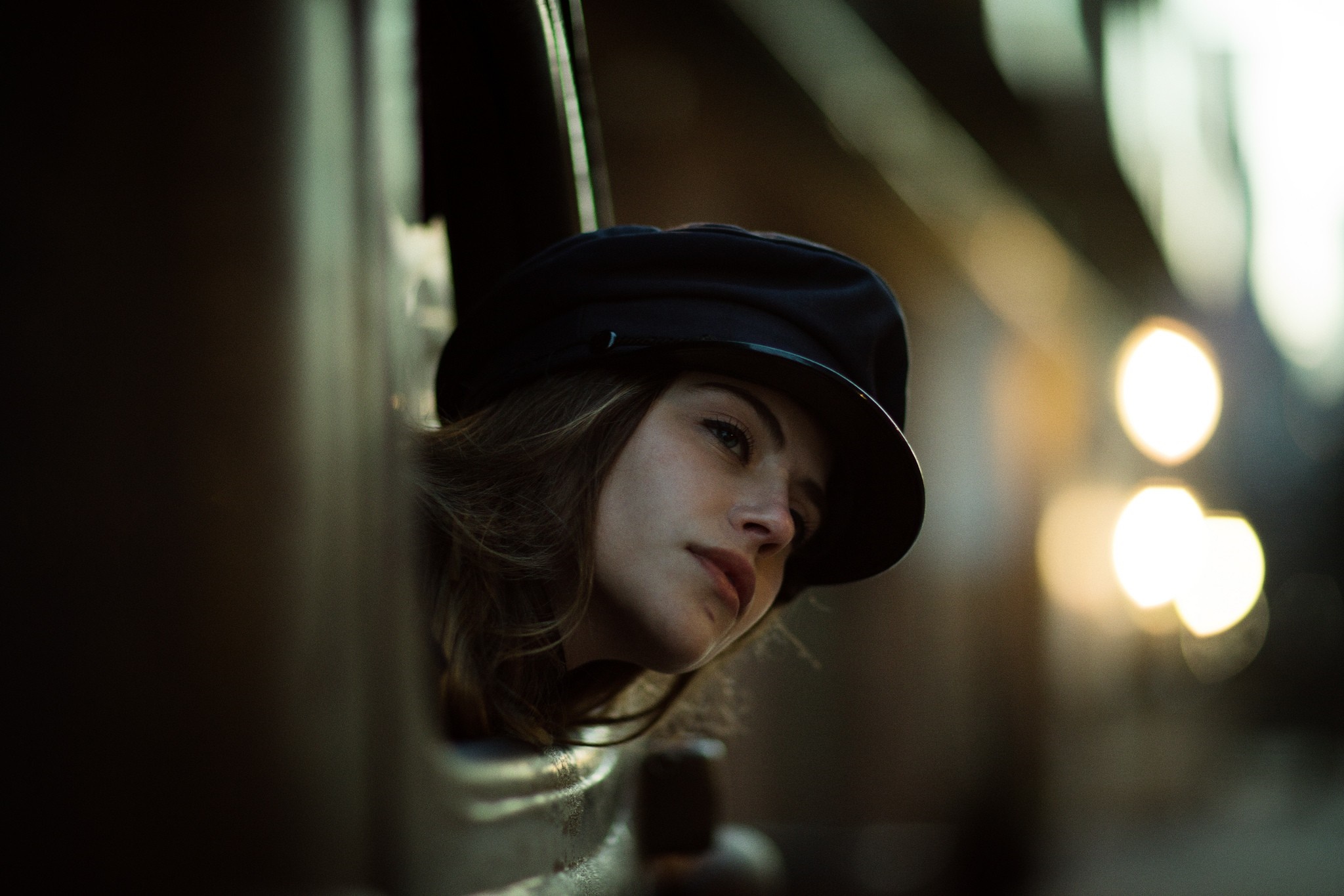 Woman wearing a black hat looking out a window HD Wallpaper