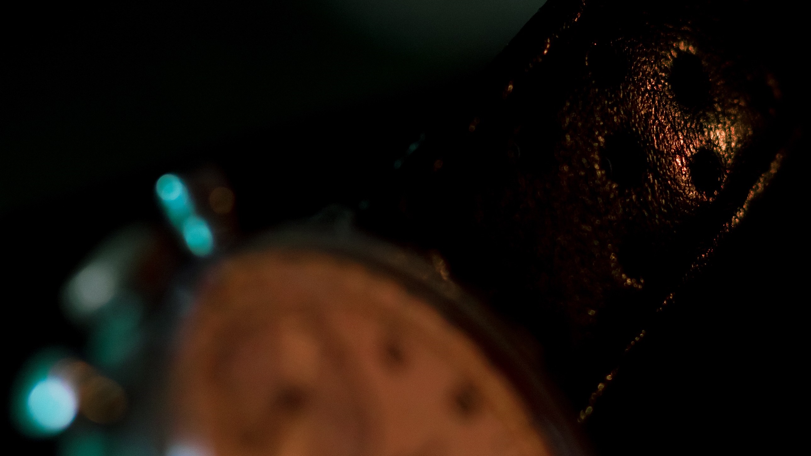 Close-up of a dark, textured object with circular indentations HD Wallpaper