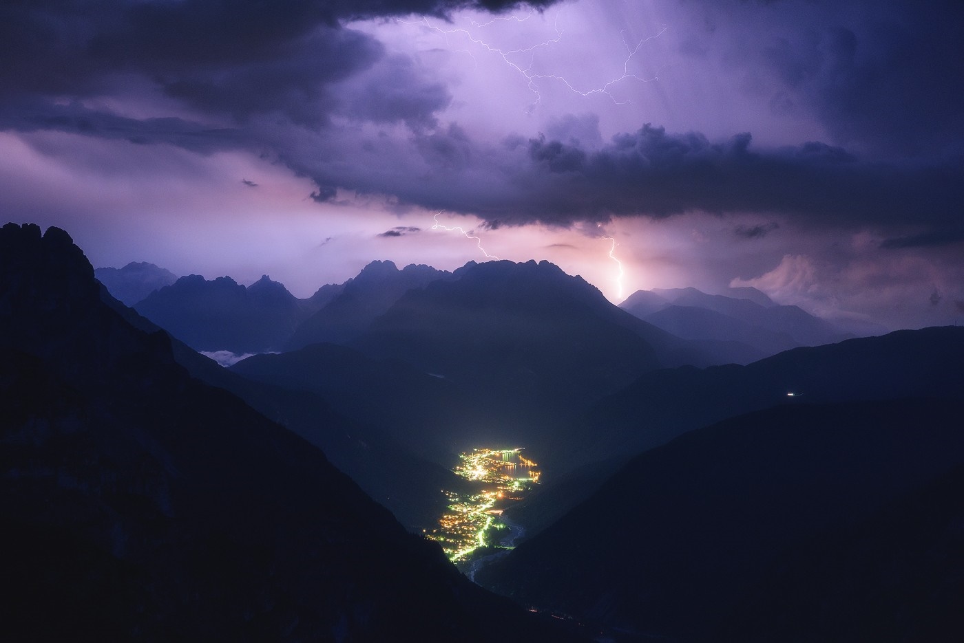 Lightning storm over a mountain valley town at night HD Wallpaper