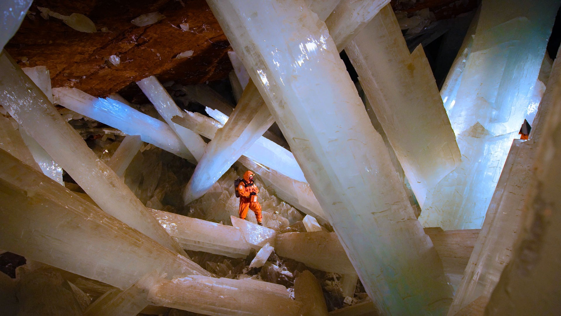 Cave with giant selenite crystals and a person HD Wallpaper
