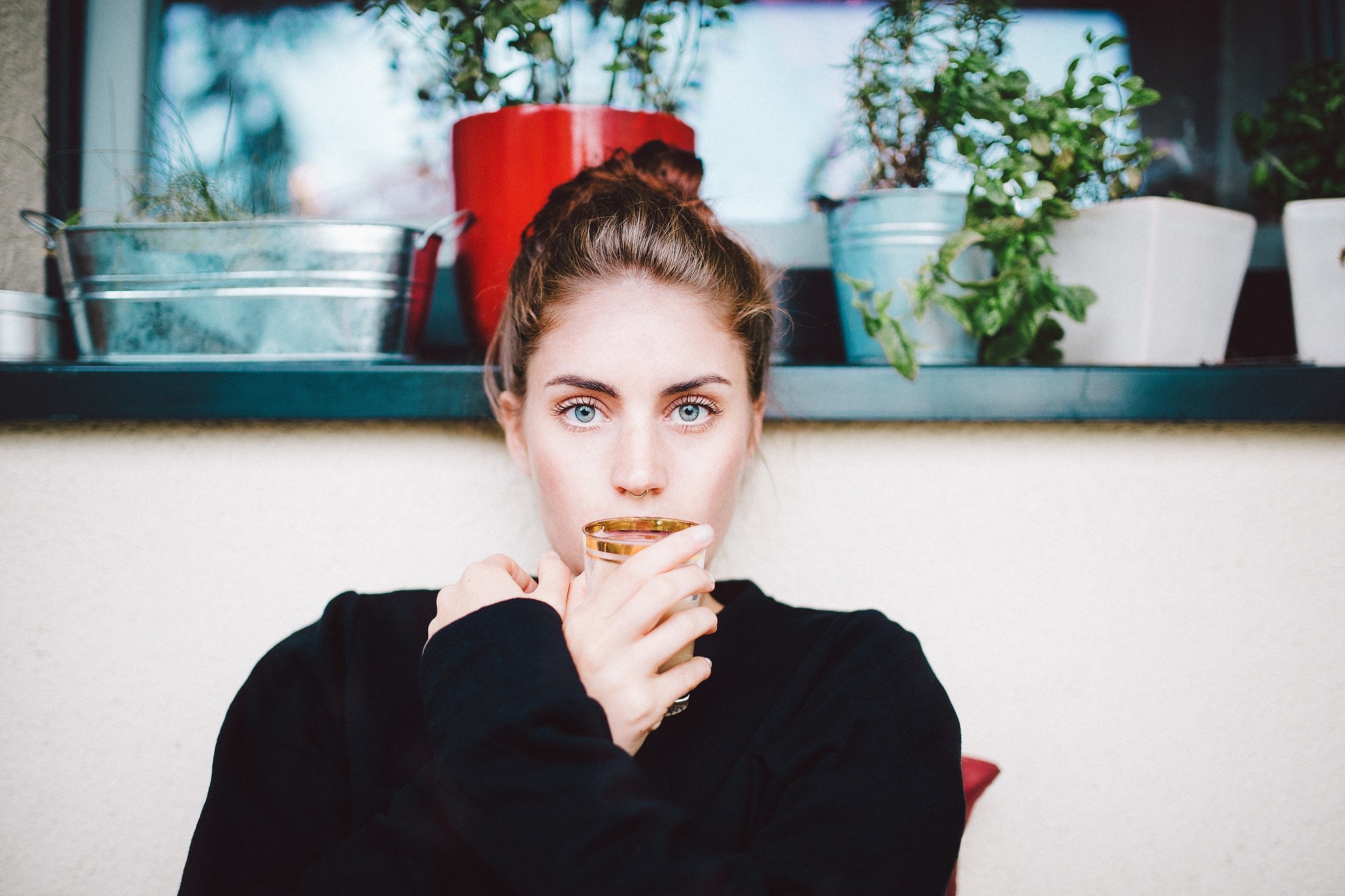 Woman with blue eyes drinking from a glass HD Wallpaper