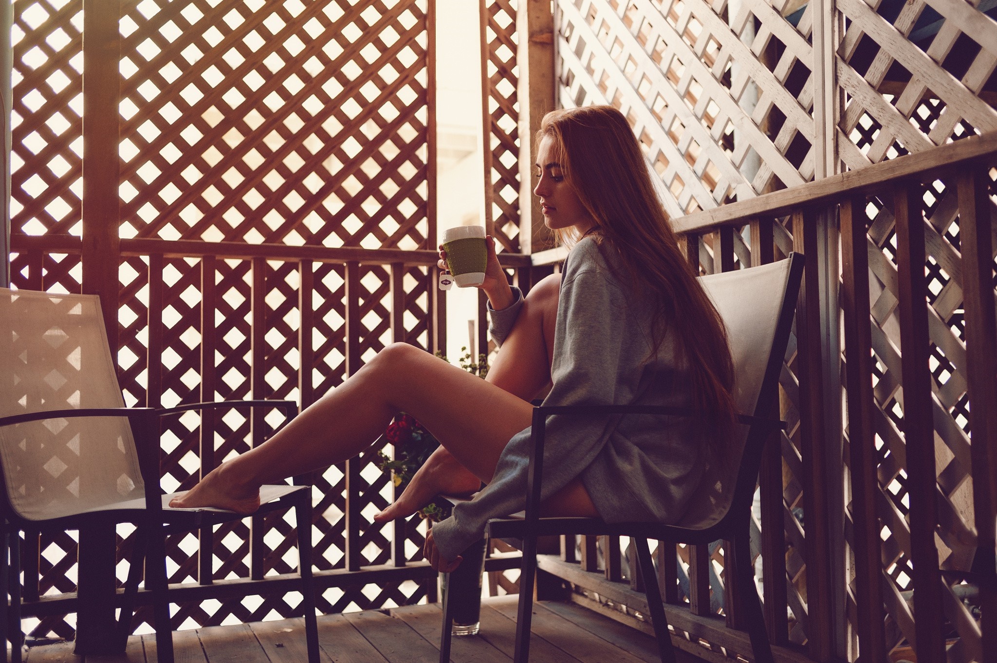 Woman with long hair holding a cup on a balcony HD Wallpaper