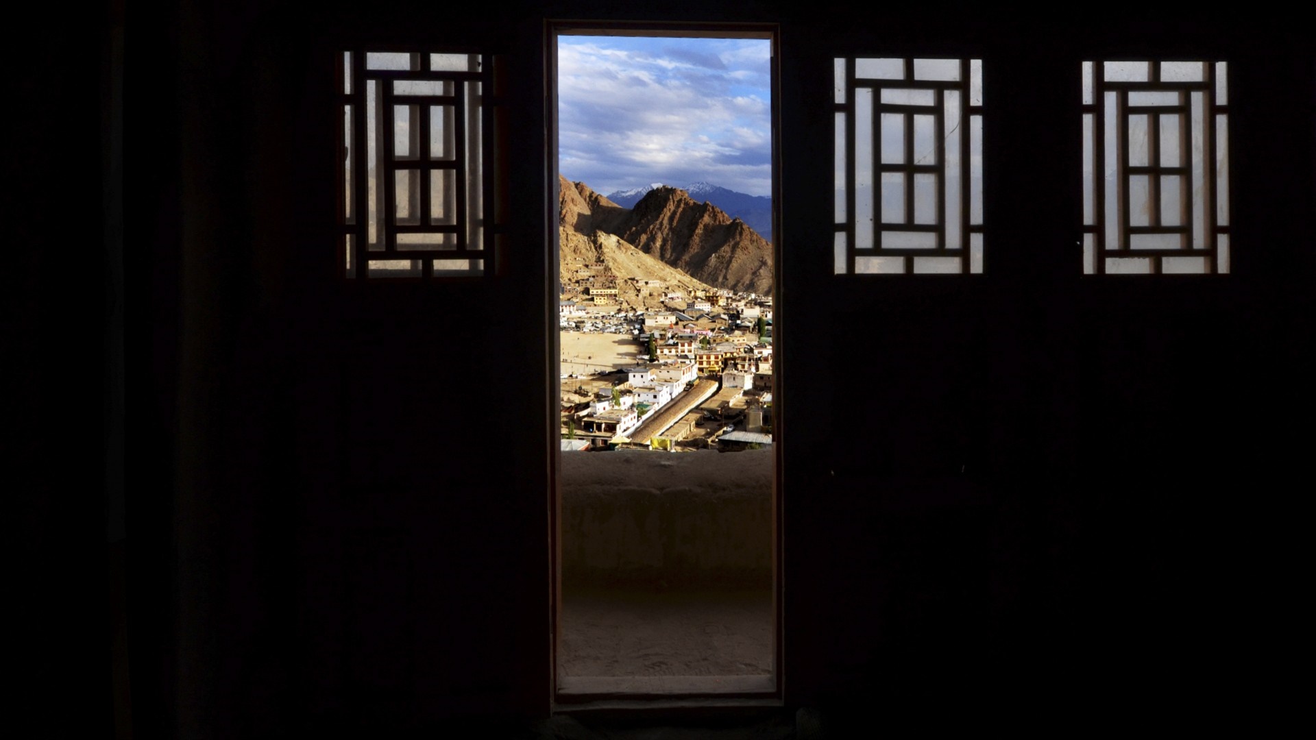 View of a town and mountains through a doorway HD Wallpaper