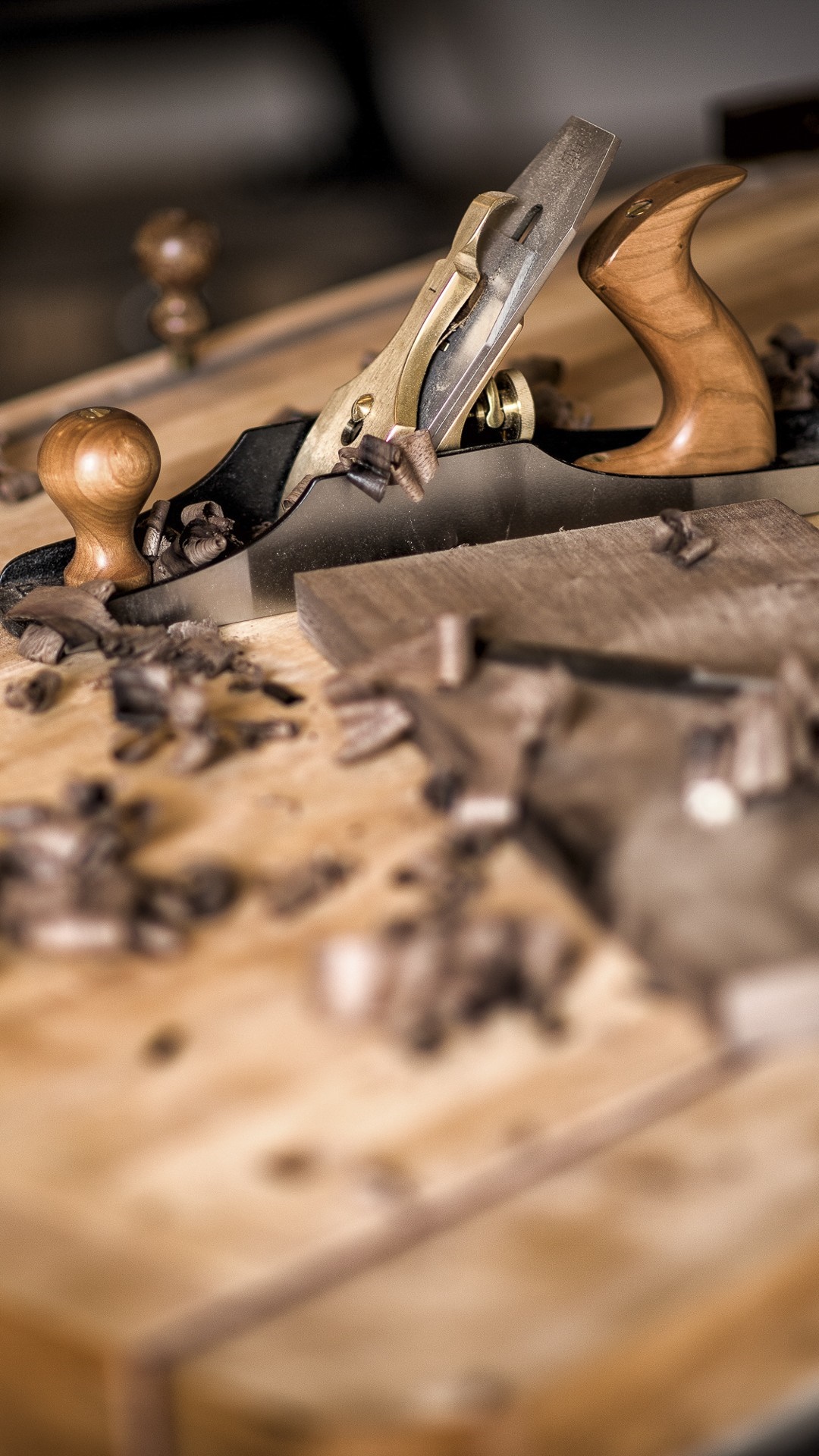 Woodworking plane with shavings on a wooden surface HD Wallpaper