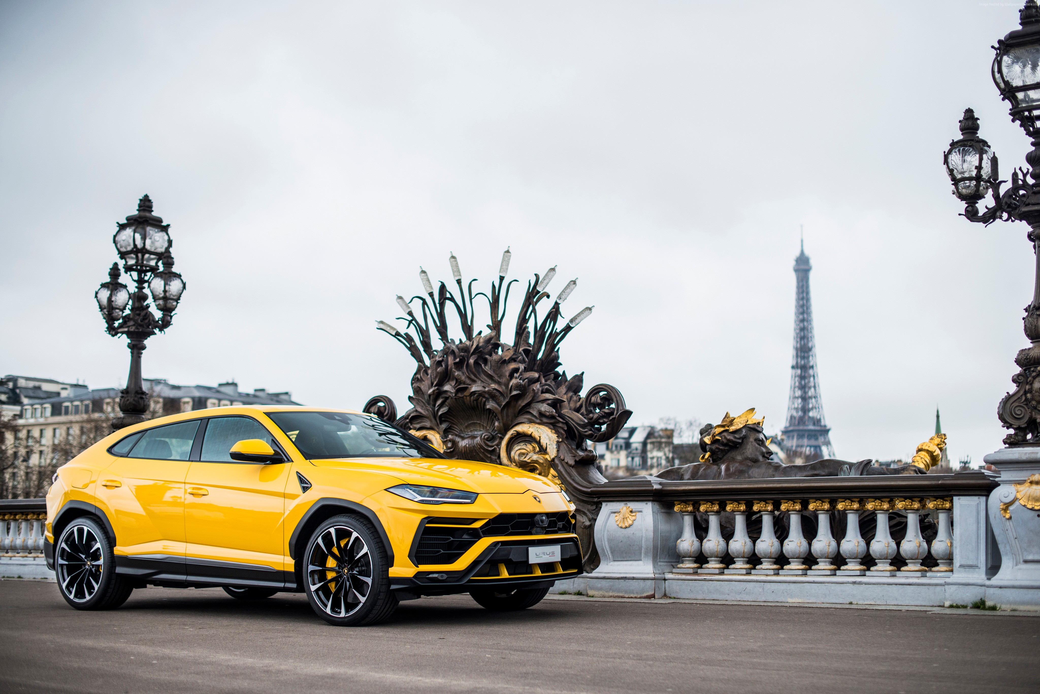 Yellow Lamborghini Urus on a bridge in Paris with Eiffel Tower HD Wallpaper