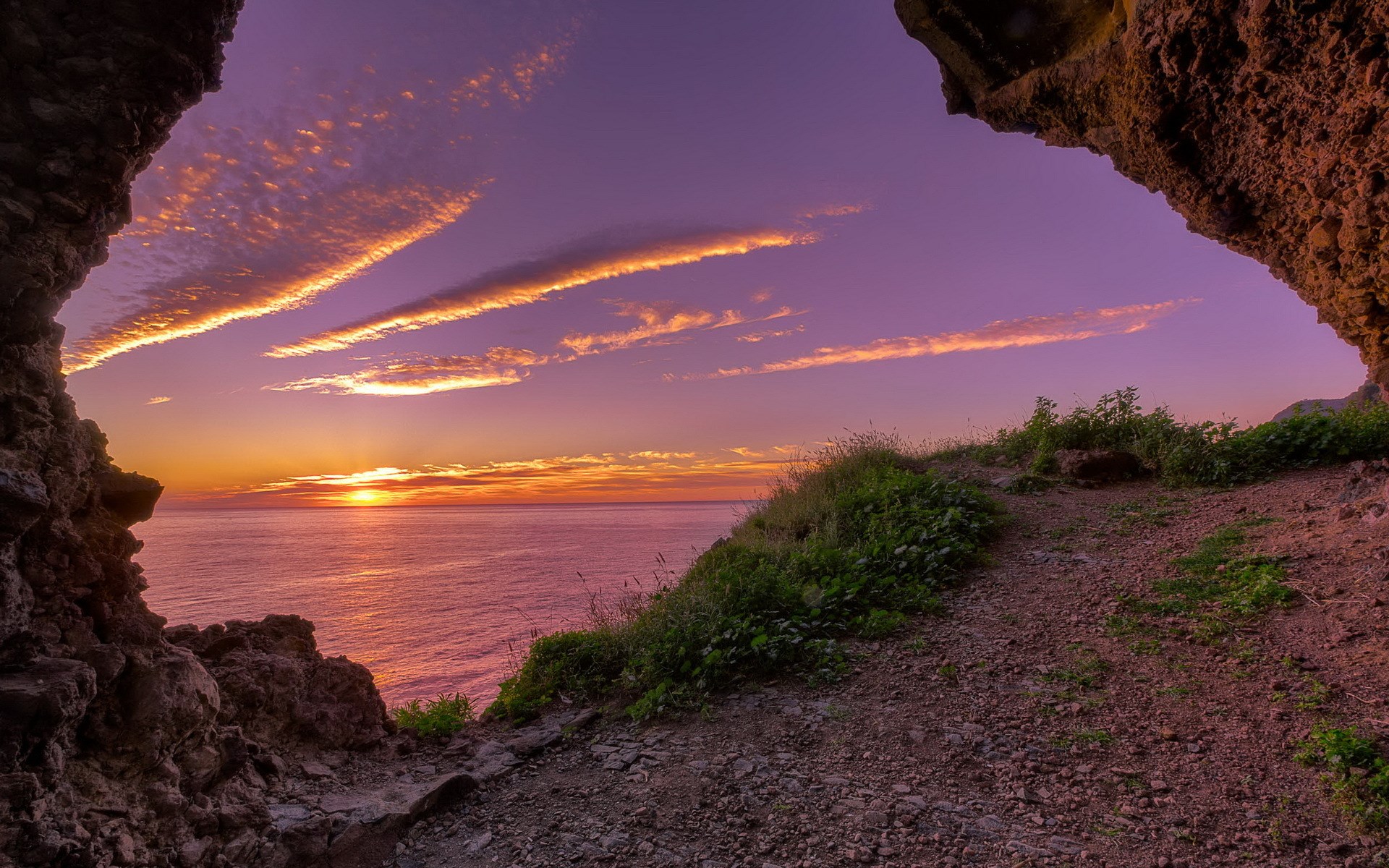 Cave entrance overlooking ocean sunset HD Wallpaper