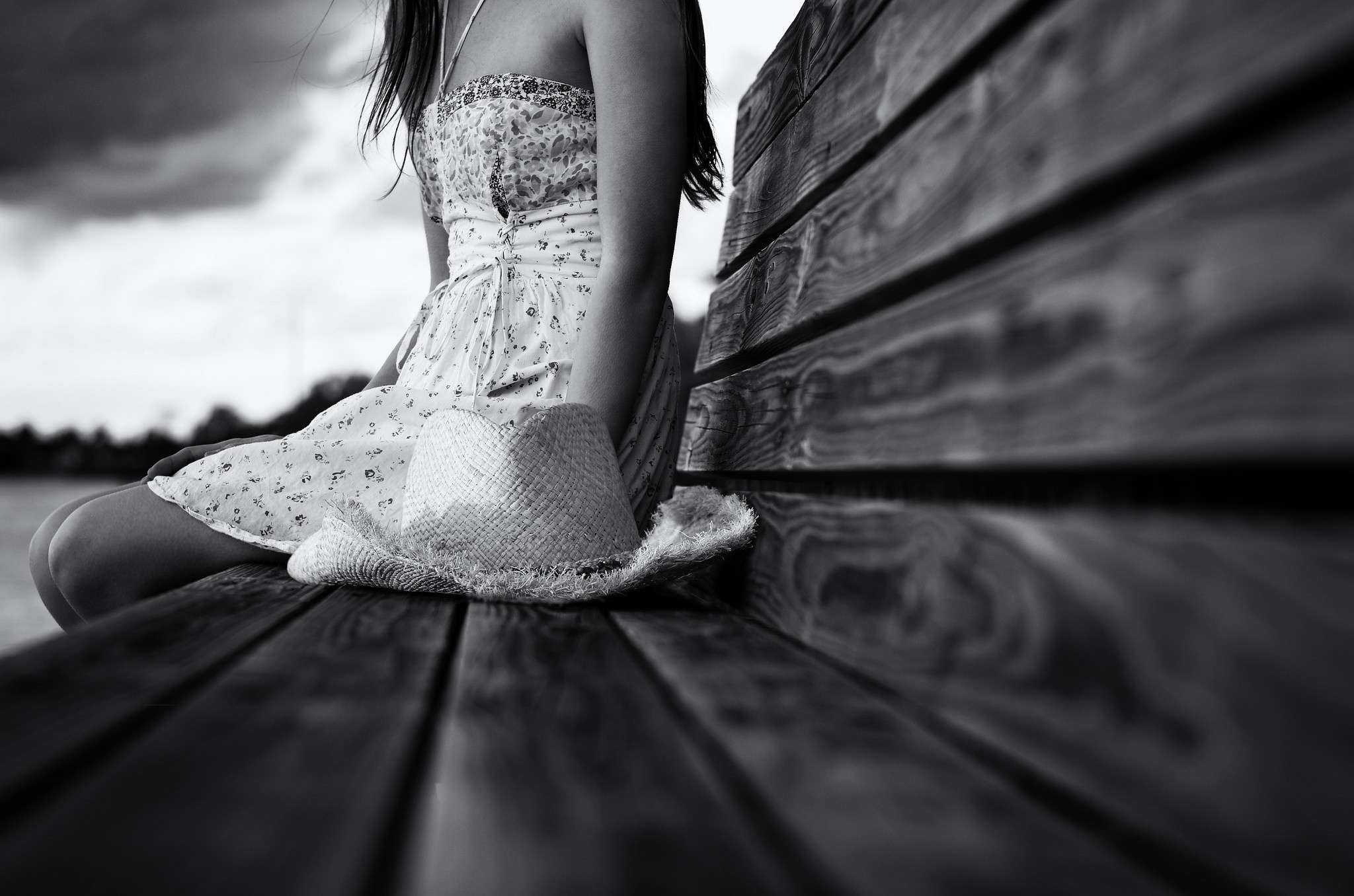 Woman in dress with hat sitting on a wooden bench HD Wallpaper