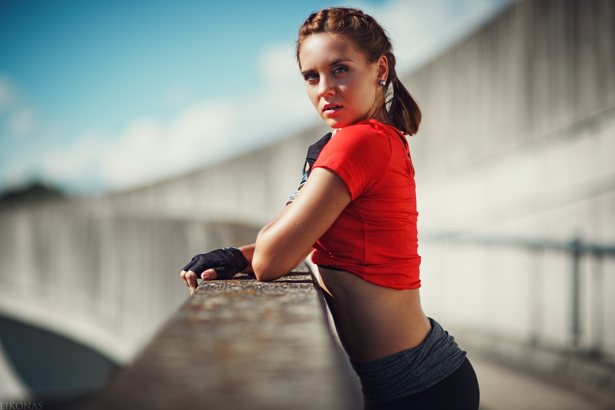 Woman in red t-shirt and gloves leaning on railing HD Wallpaper