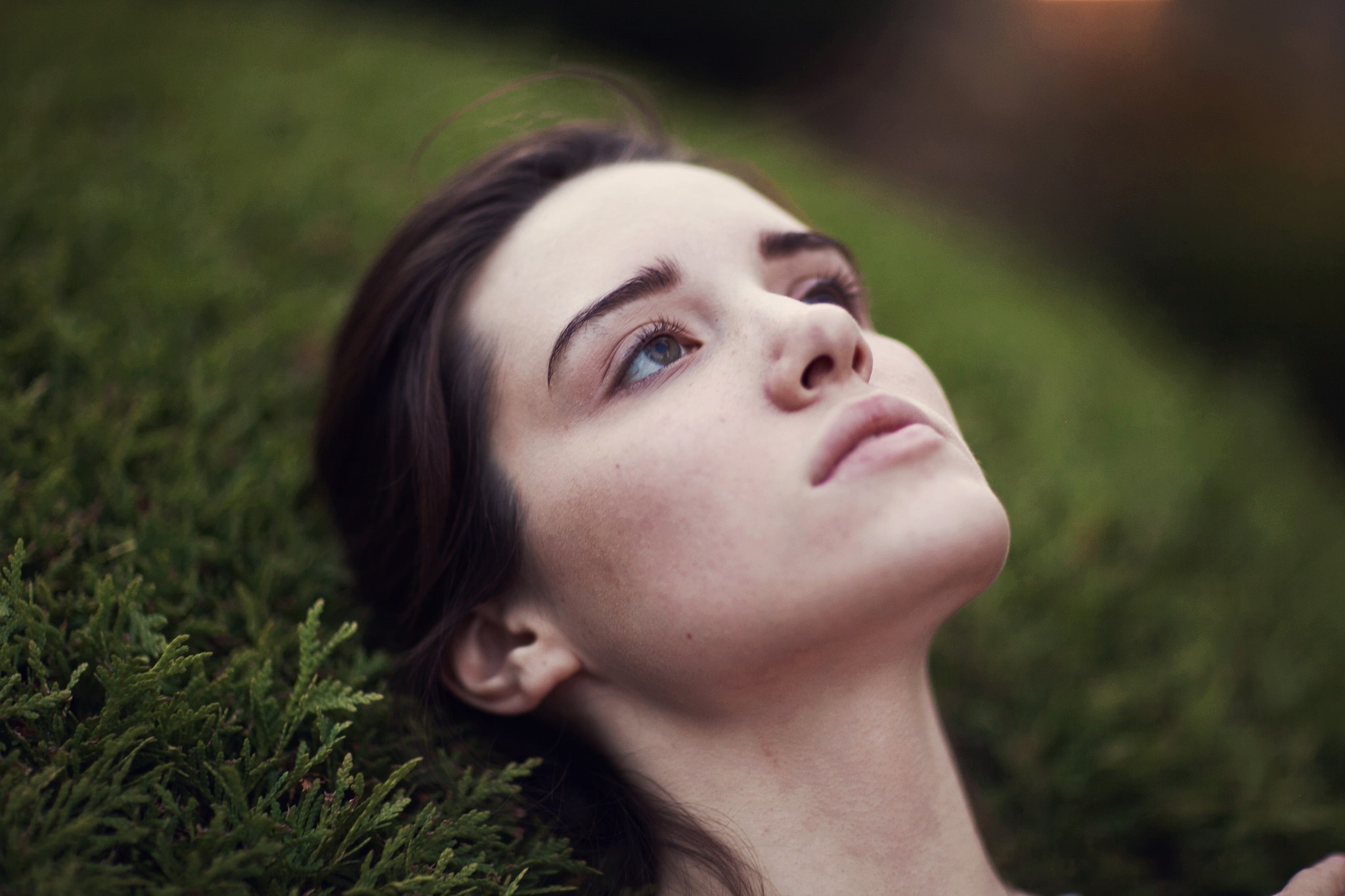 Woman lying on grass looking up HD Wallpaper