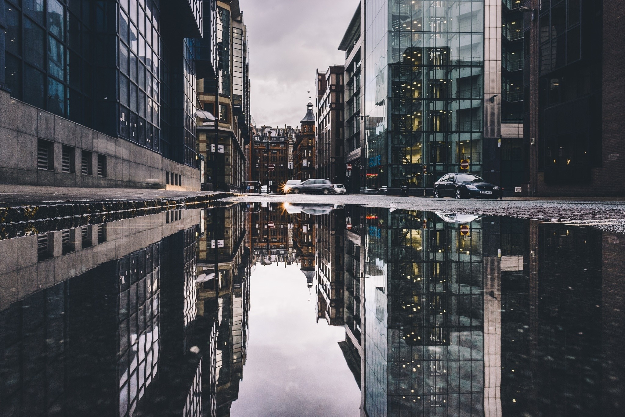 City street with reflections in a puddle HD Wallpaper