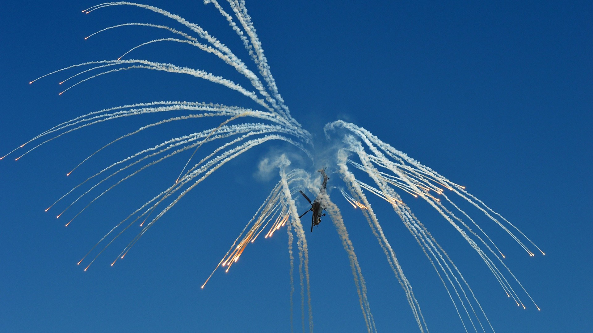 Helicopters performing aerial maneuvers with flares HD Wallpaper
