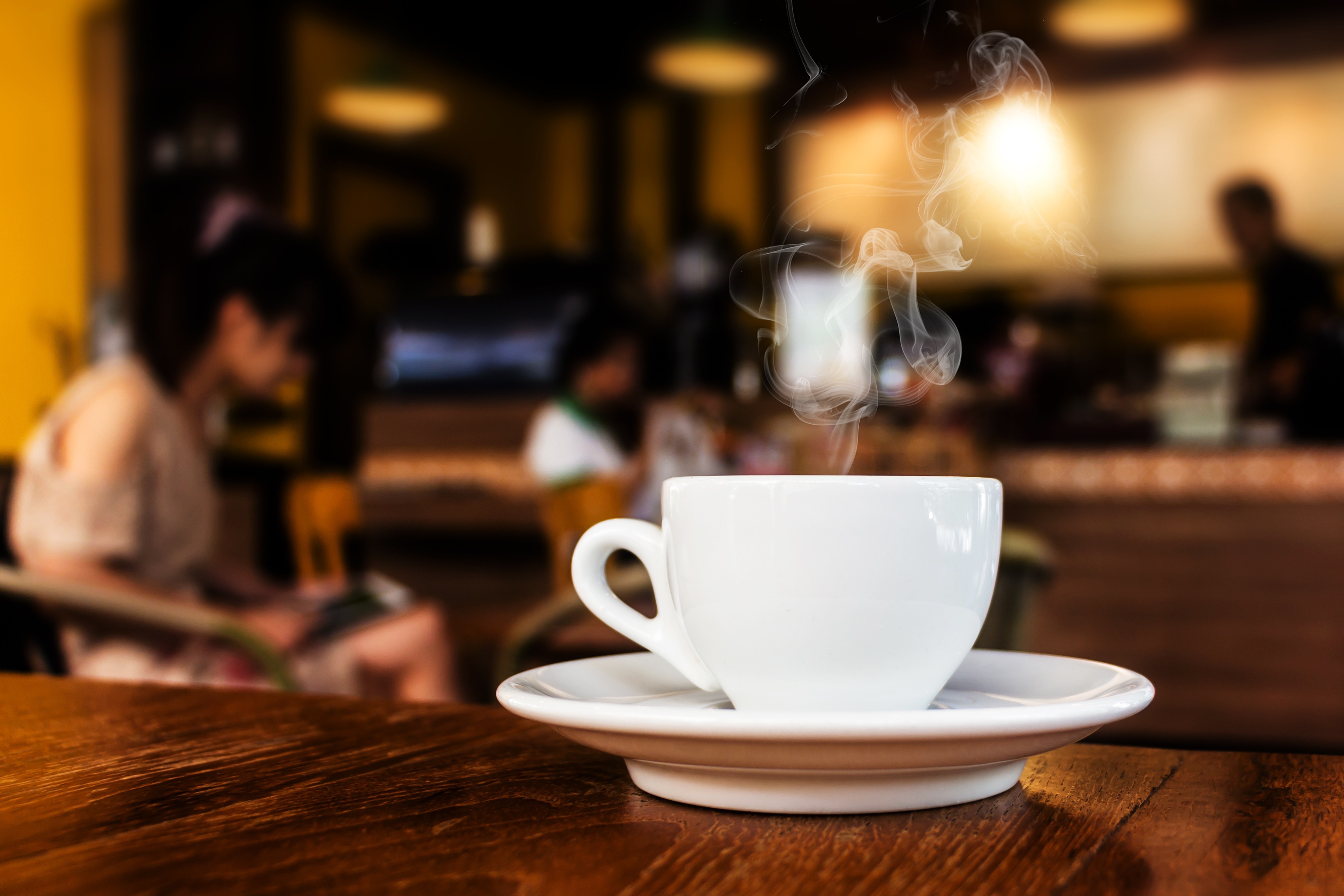 Hot coffee cup with steam in a cafe HD Wallpaper