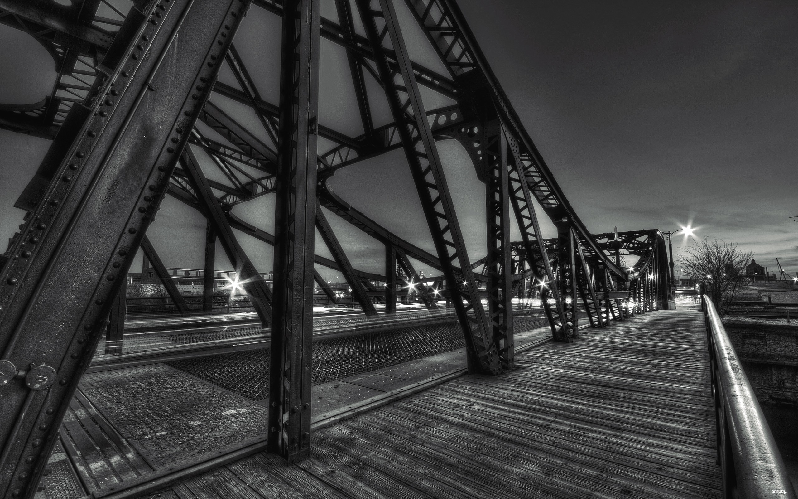 Monochrome view of a steel truss bridge at night HD Wallpaper