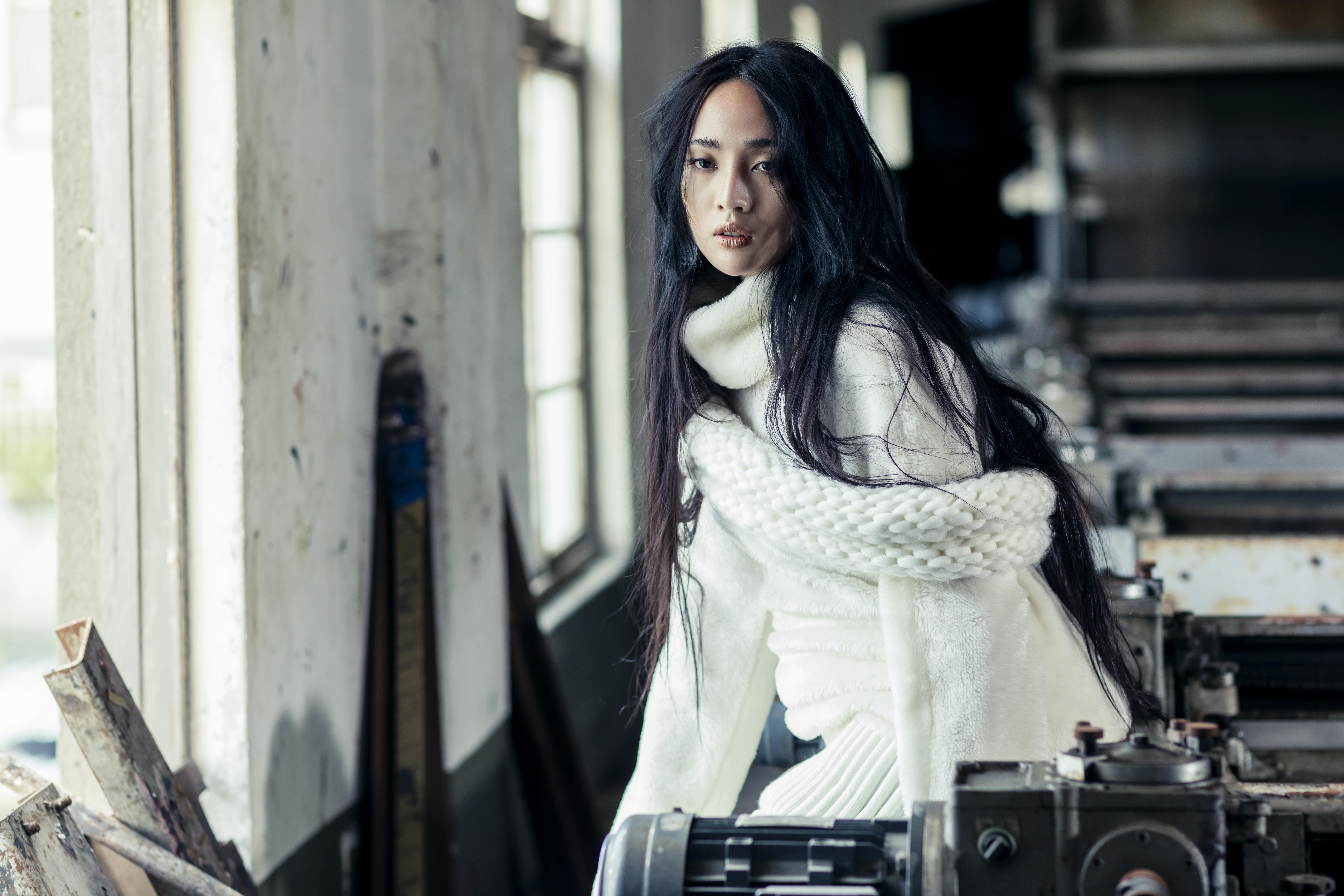 Woman in white sweater in industrial setting HD Wallpaper