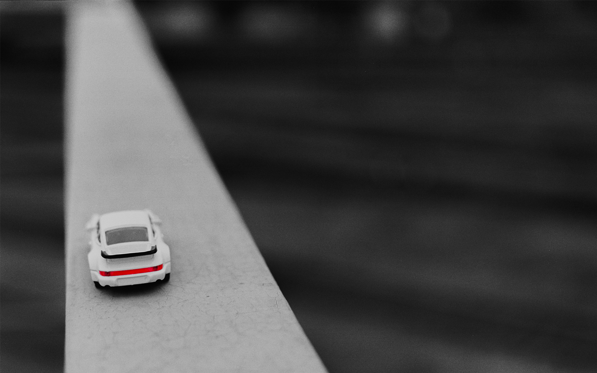 White toy Porsche with red taillight on a railing HD Wallpaper