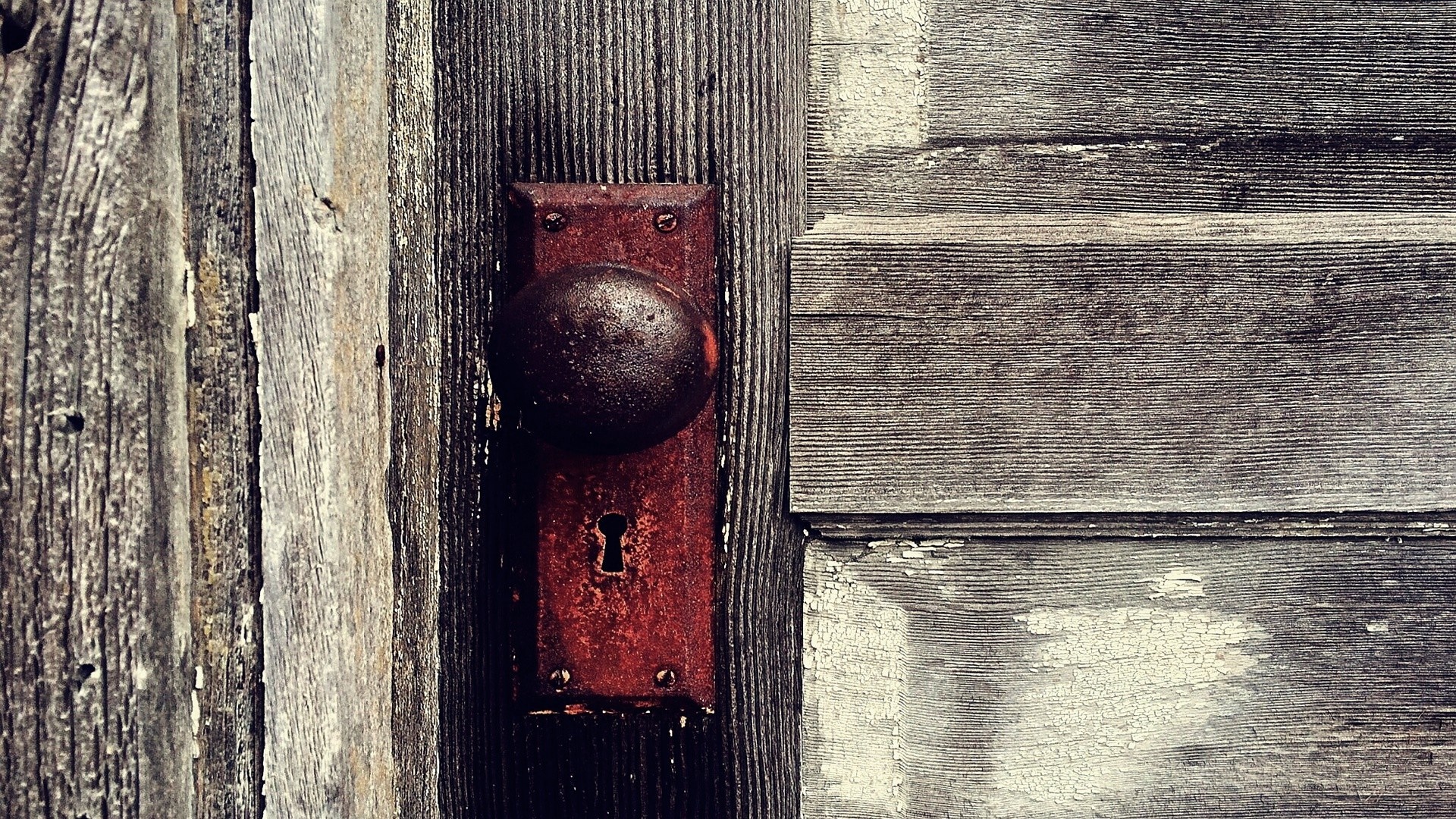 Old rusty doorknob on a weathered wooden door HD Wallpaper